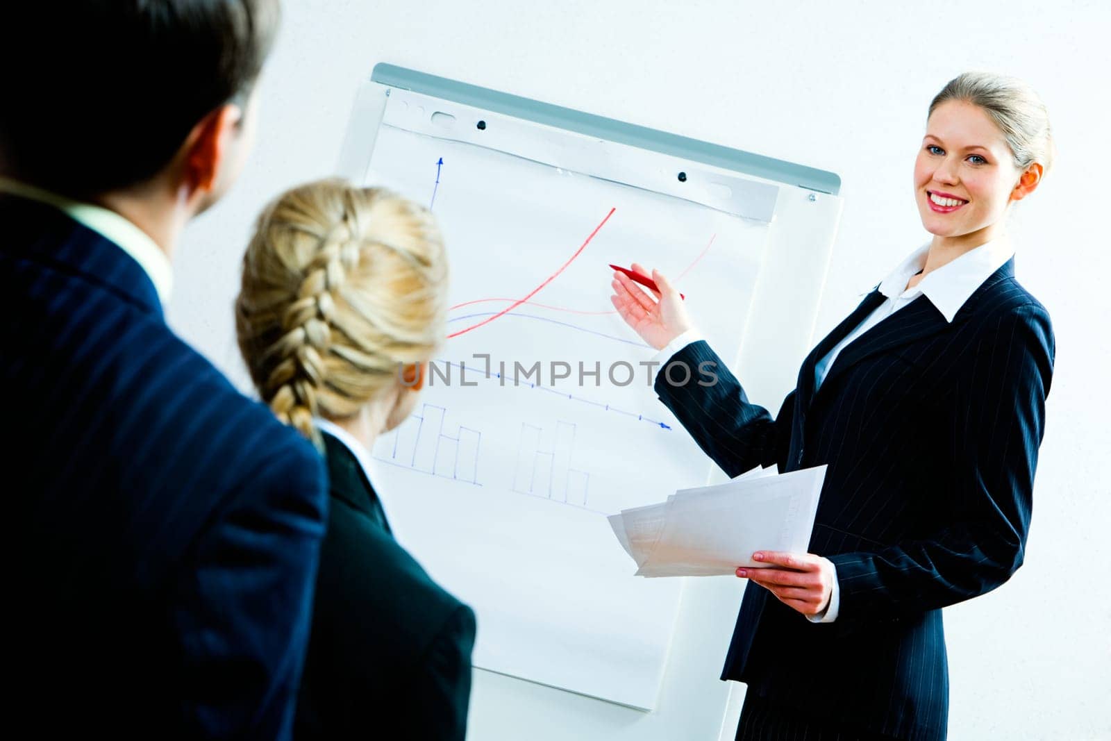 Portrait of business woman showing a plan of development to co-workers
