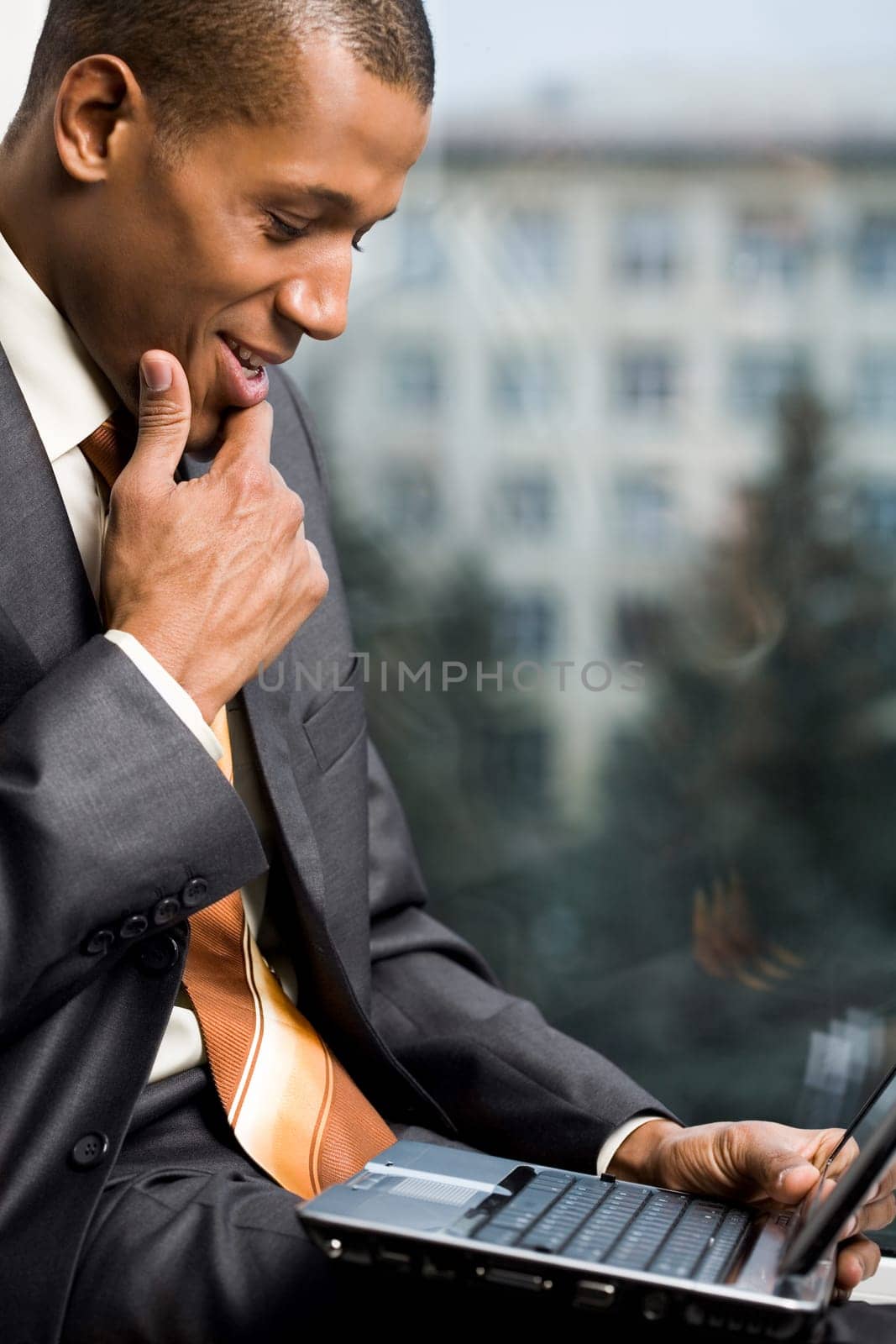 Photo of successful employee looking at laptop display during work