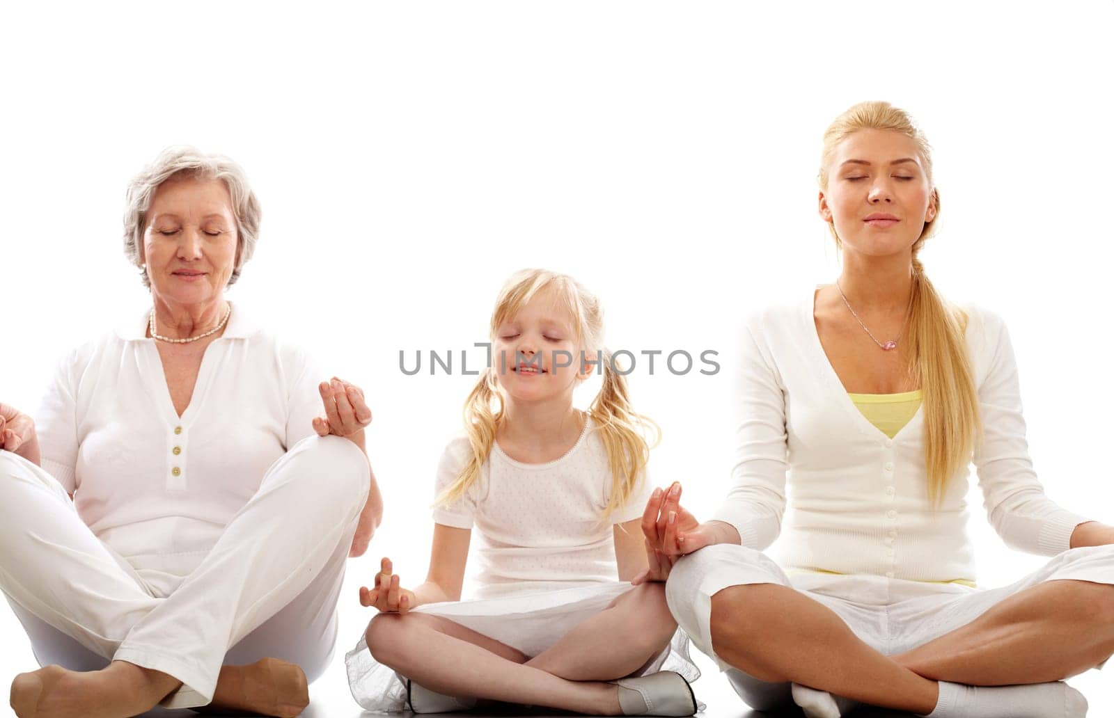 Row of grandmother, mother and child meditating together