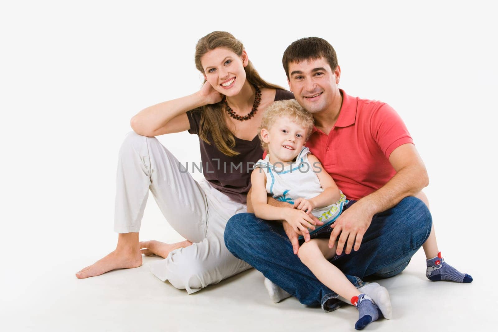 Portrait of handsome man holding boy on his knees with woman near by