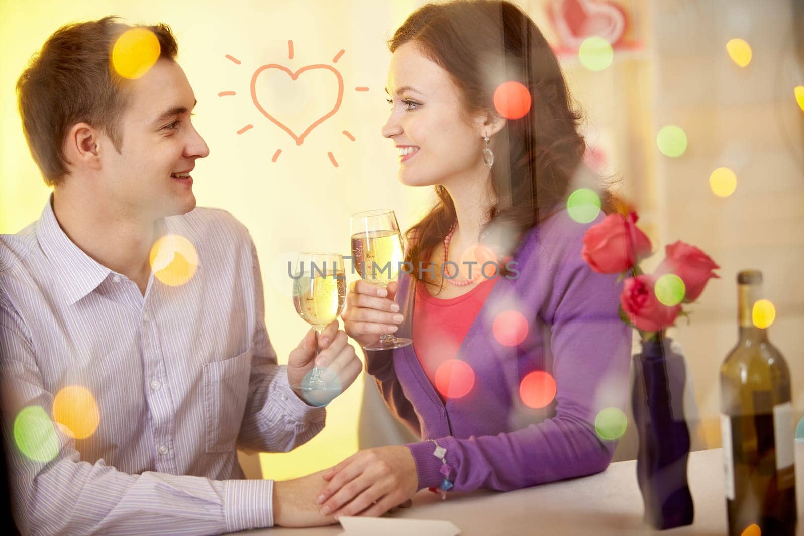 A young happy couple sitting in restaurant and drinking wine