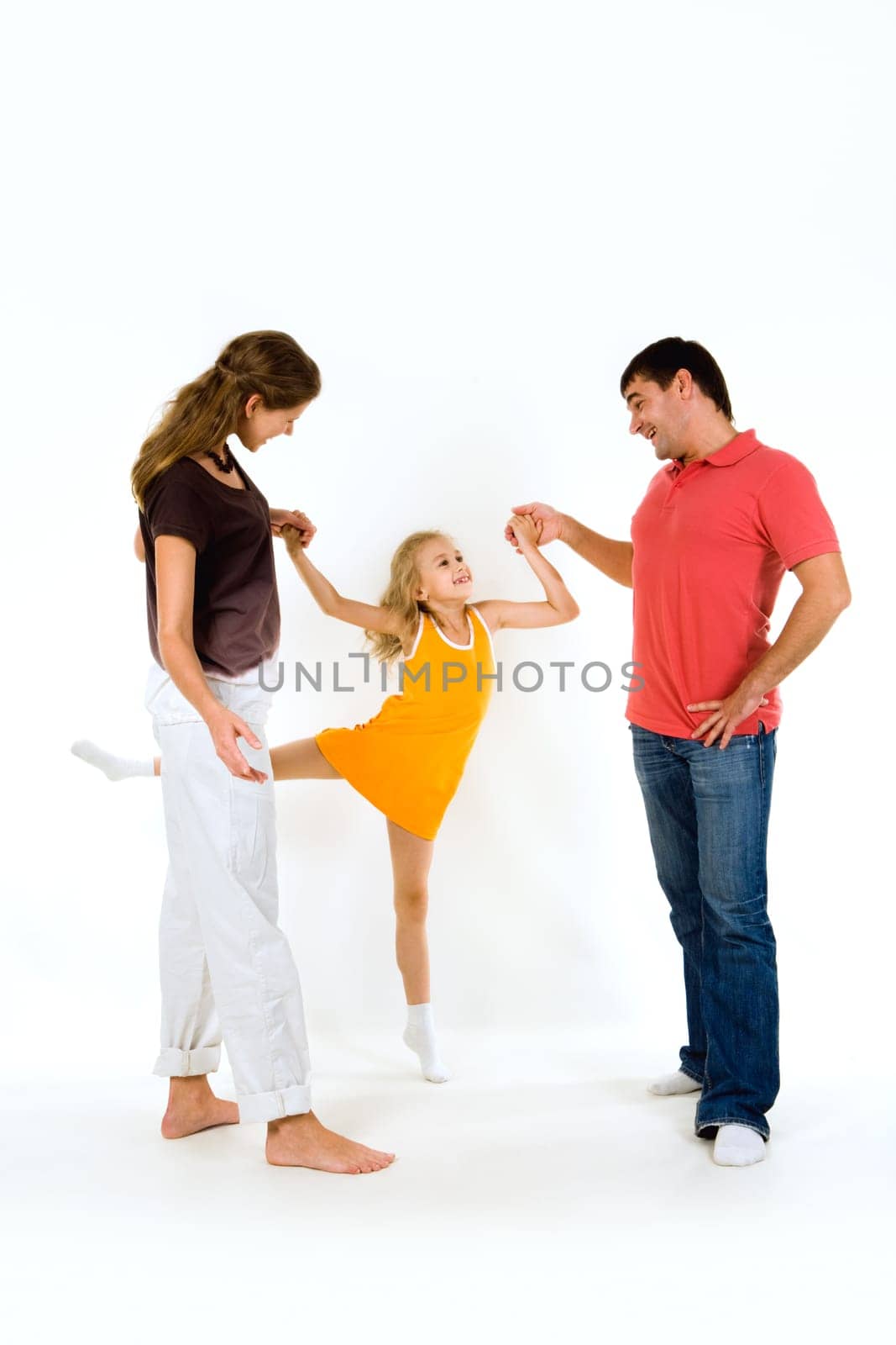 Image of young girl doing exercise holding her parents by hands