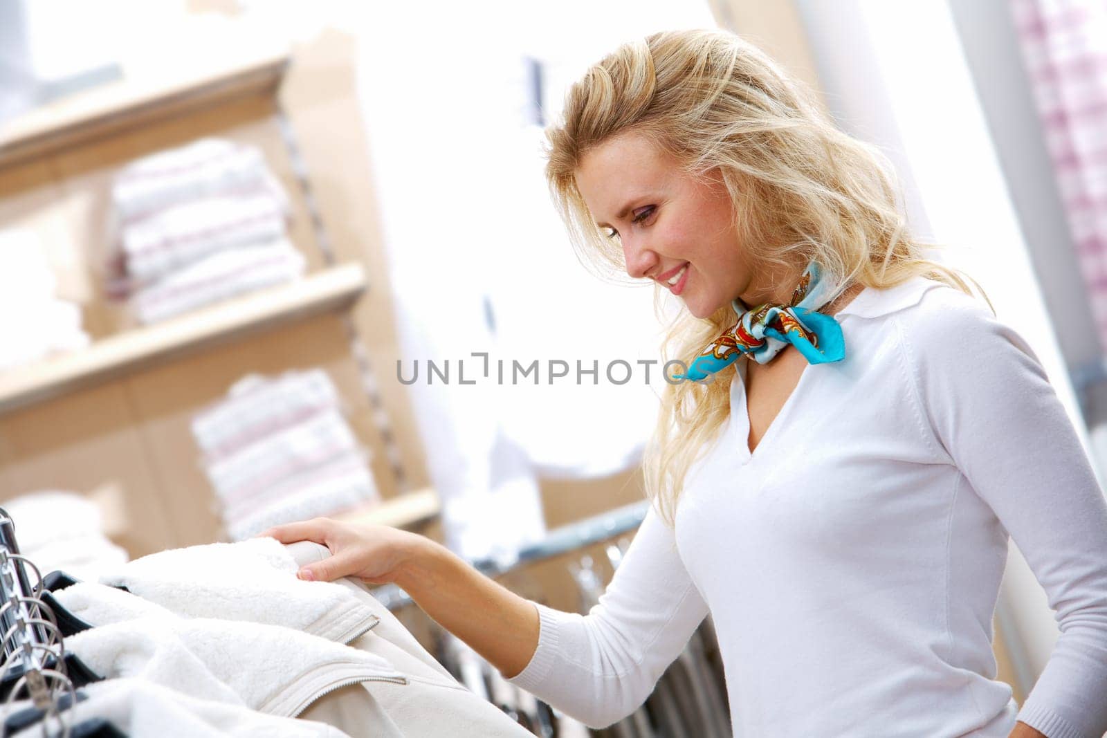Portrait of pretty woman choosing new winter coat in clothing department