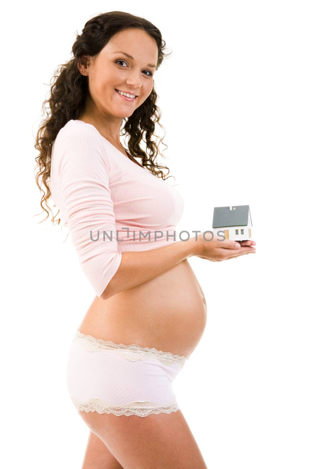 Portrait of pregnant woman holding toy house in hands and smiling at camera