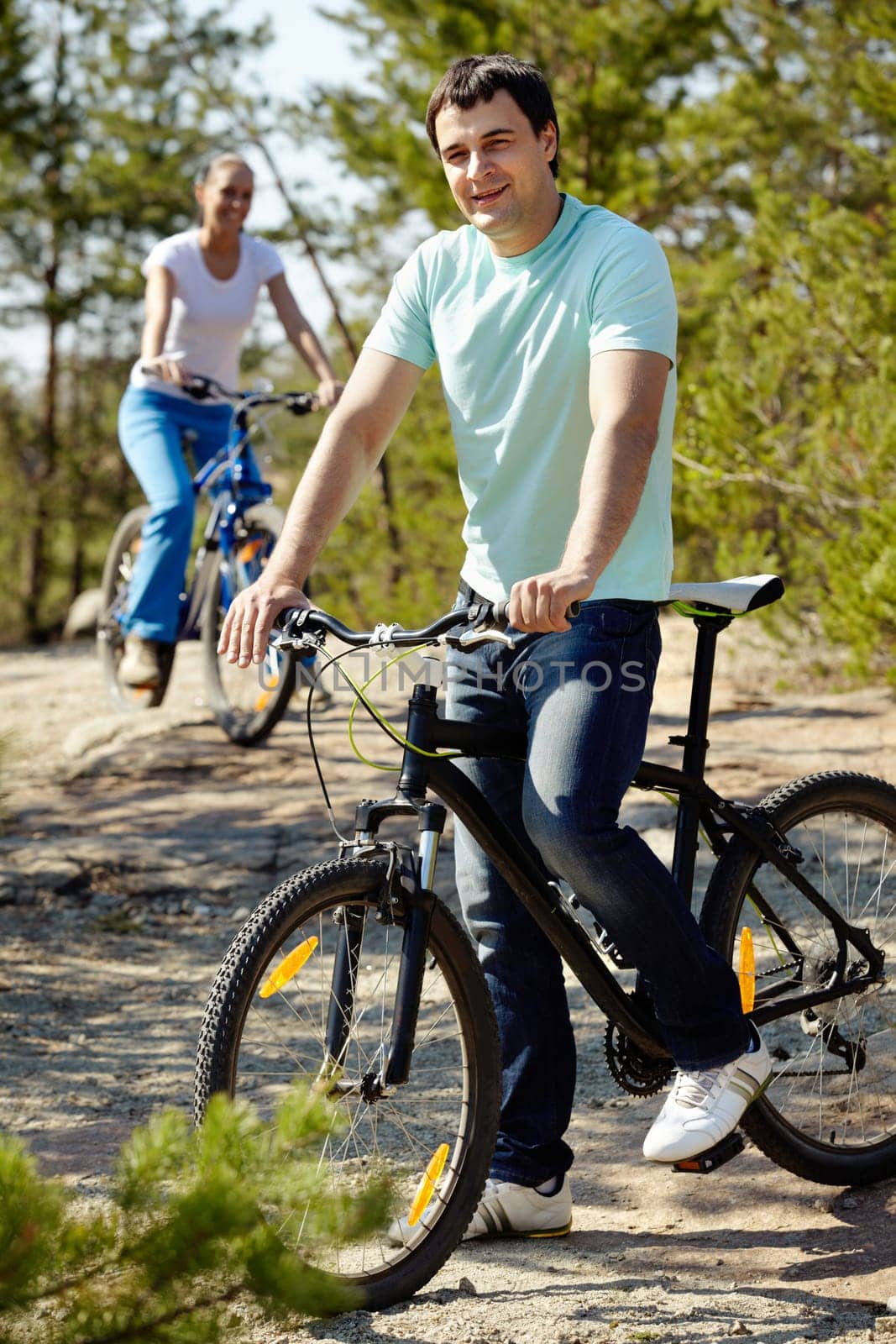 A man on bicycle looking at camera and smiling