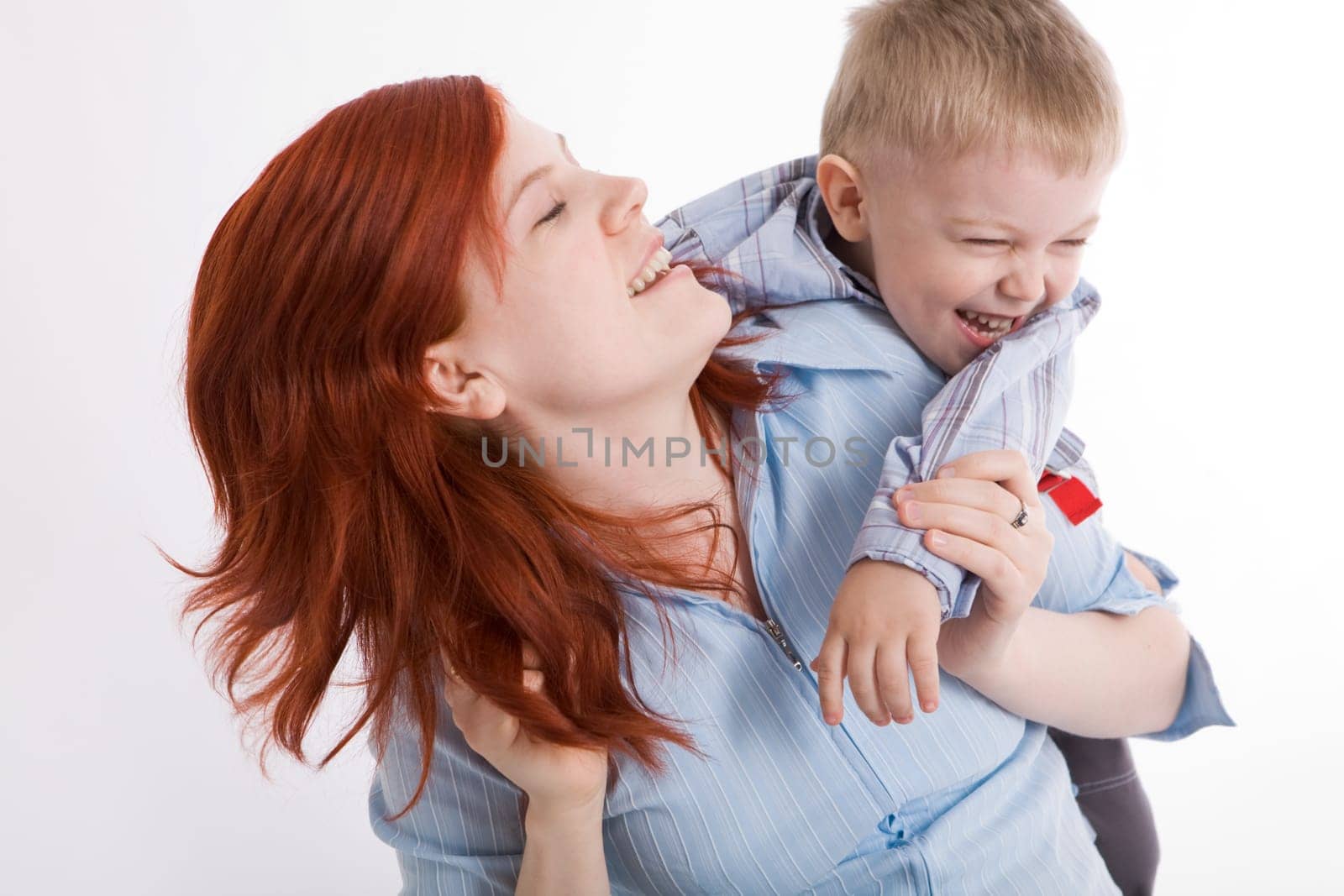 Cute child embracing his beautiful mother and both laughing