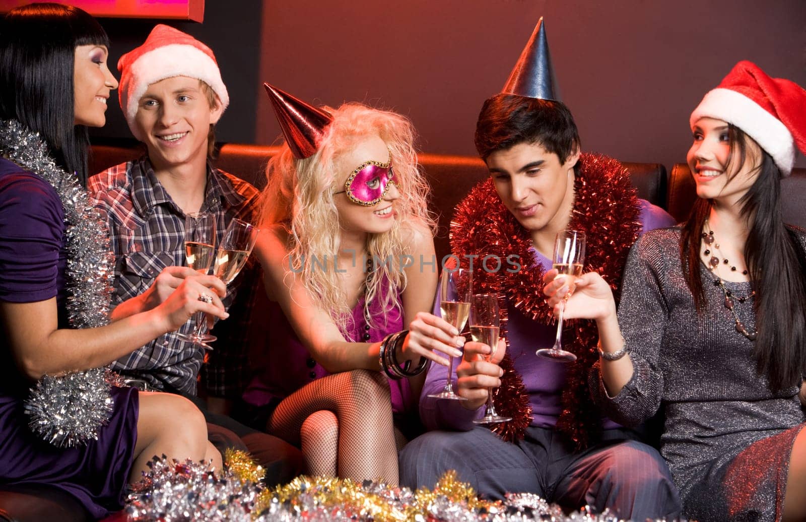 Portrait of smartly dressed young people communicating at festive table in night club
