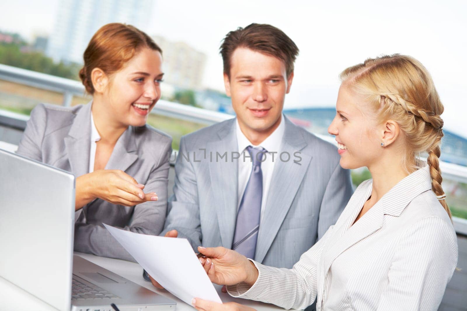 Image of successful businesspeople looking at each other while discussing plan at meeting in office