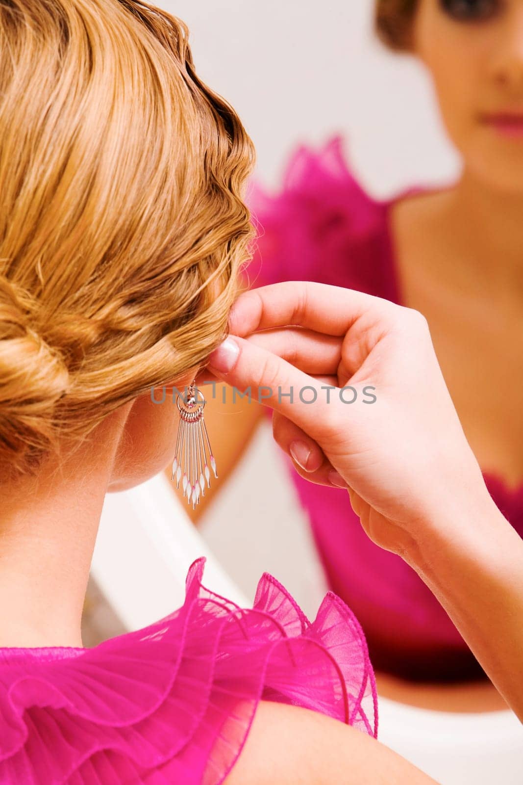 Image of pretty female putting on earrings