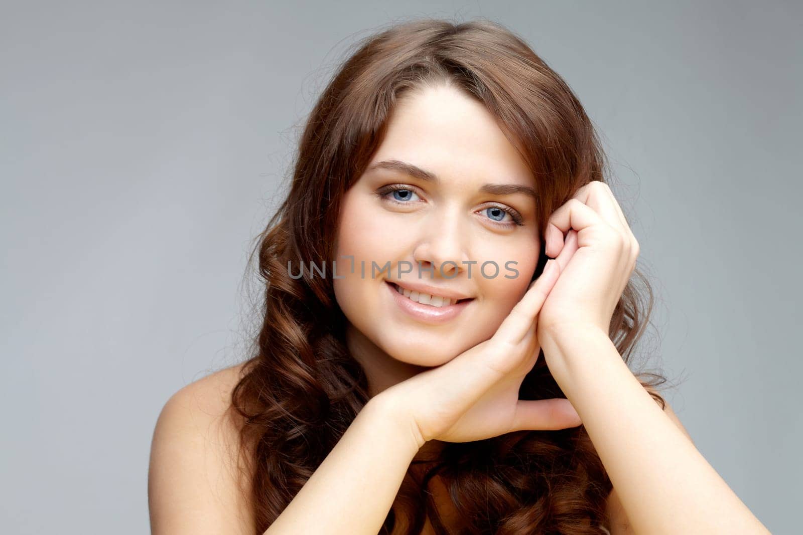 Portrait of feminine woman looking at camera on grey background