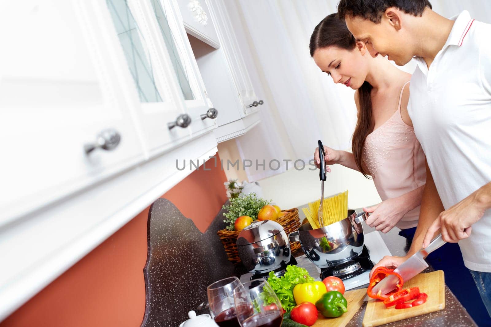 Portrait of amorous couple cooking spaghetti in the kitchen