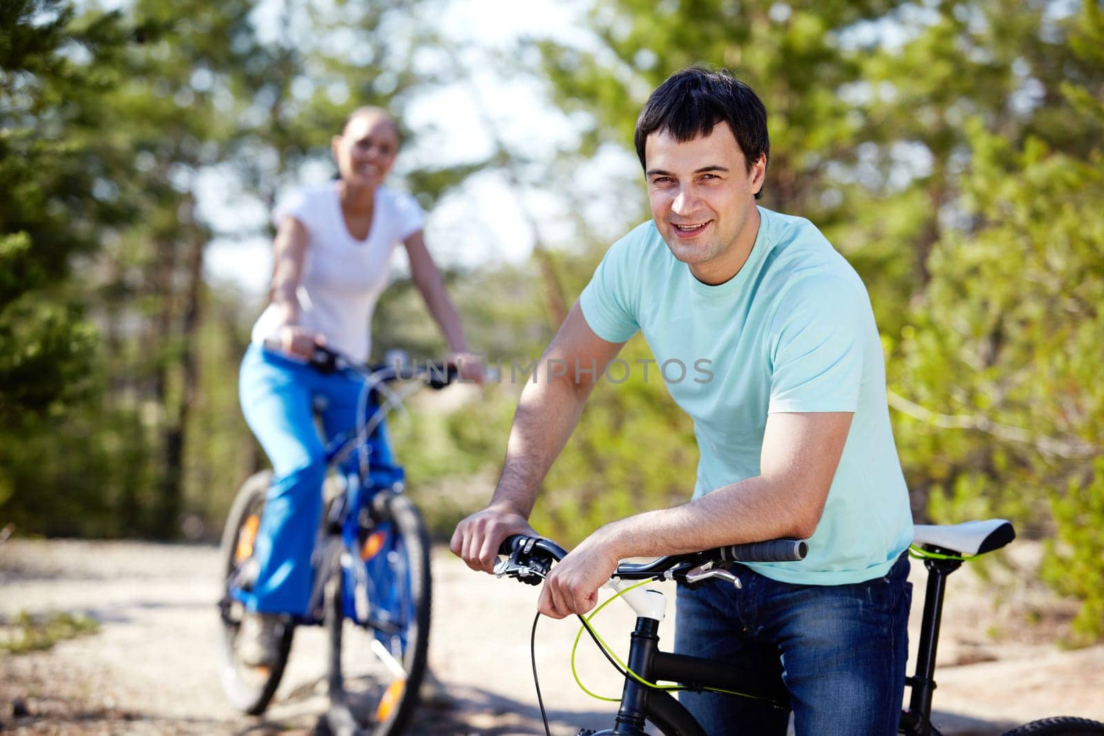 Portrait of a handsome man with his bike against his girlfriend
