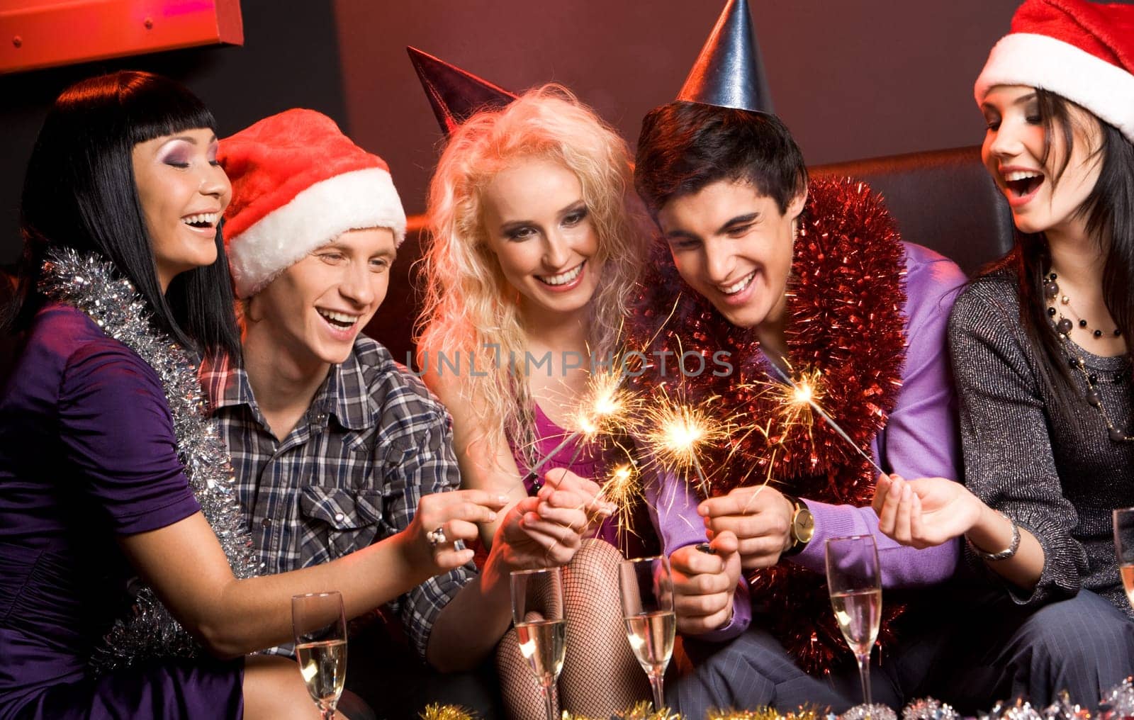 Portrait of laughing friends enjoying xmas lights at new year party