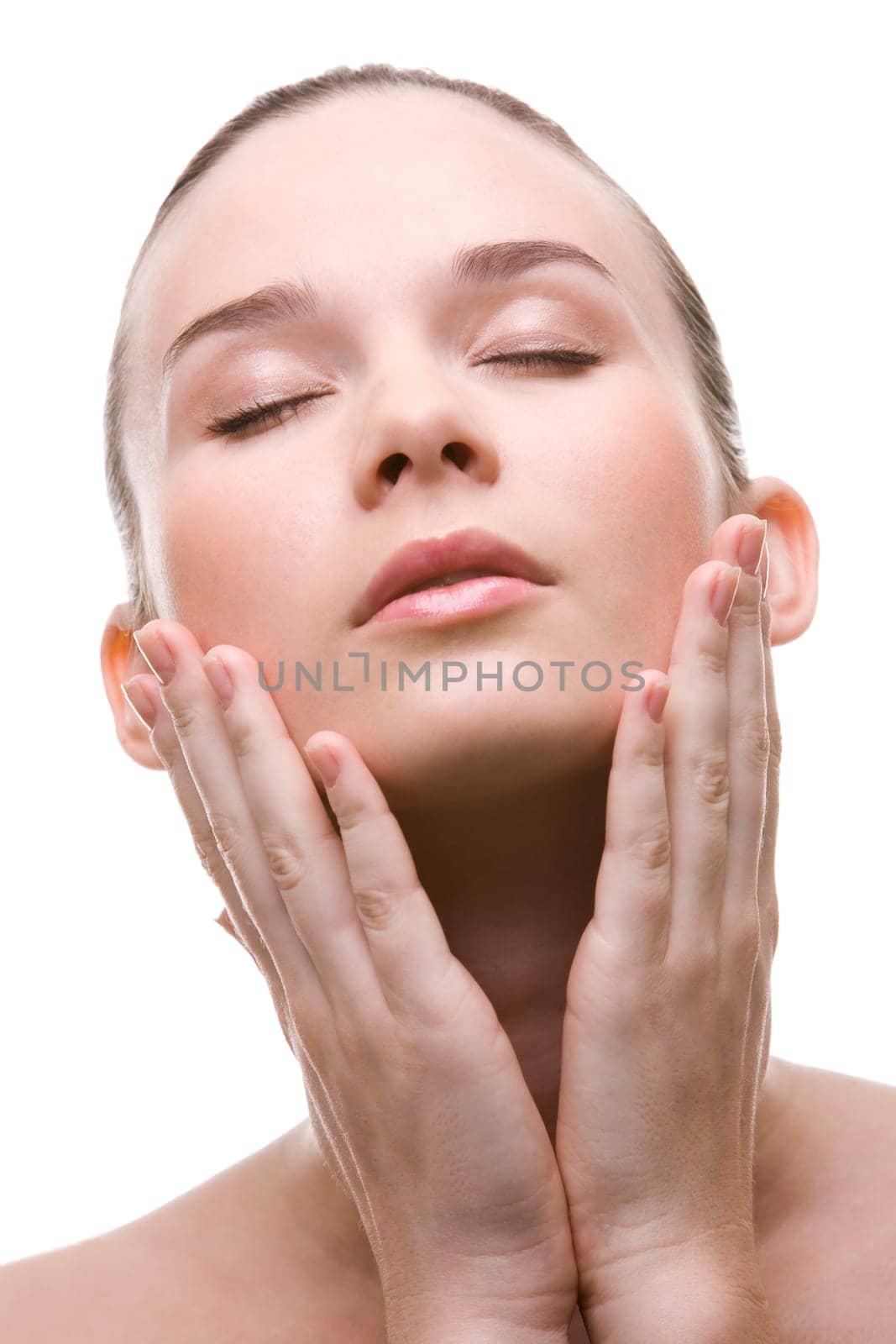 Close-up of pretty young woman touching her face