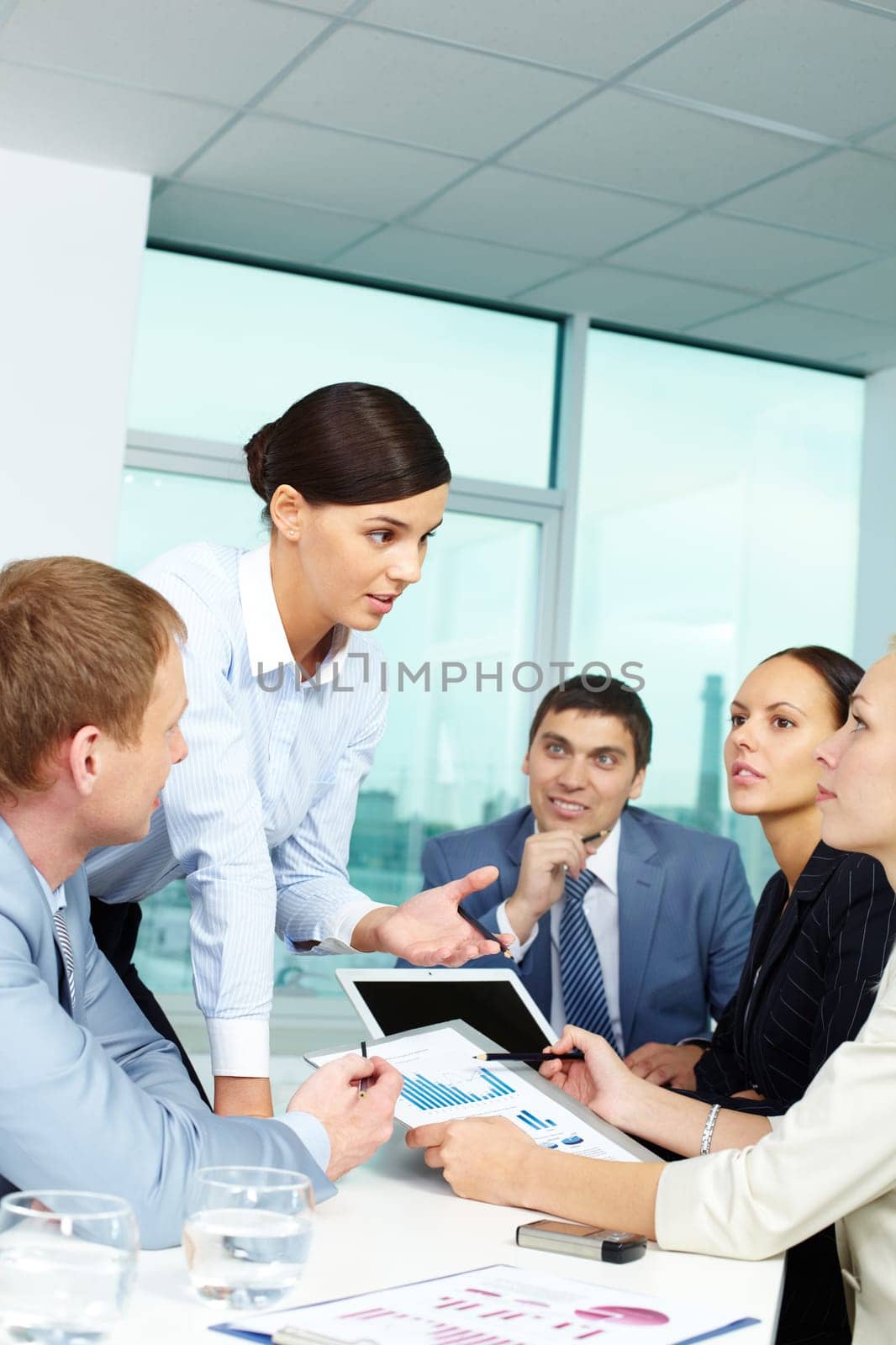 Group of business people discussing papers or sharing ideas in office