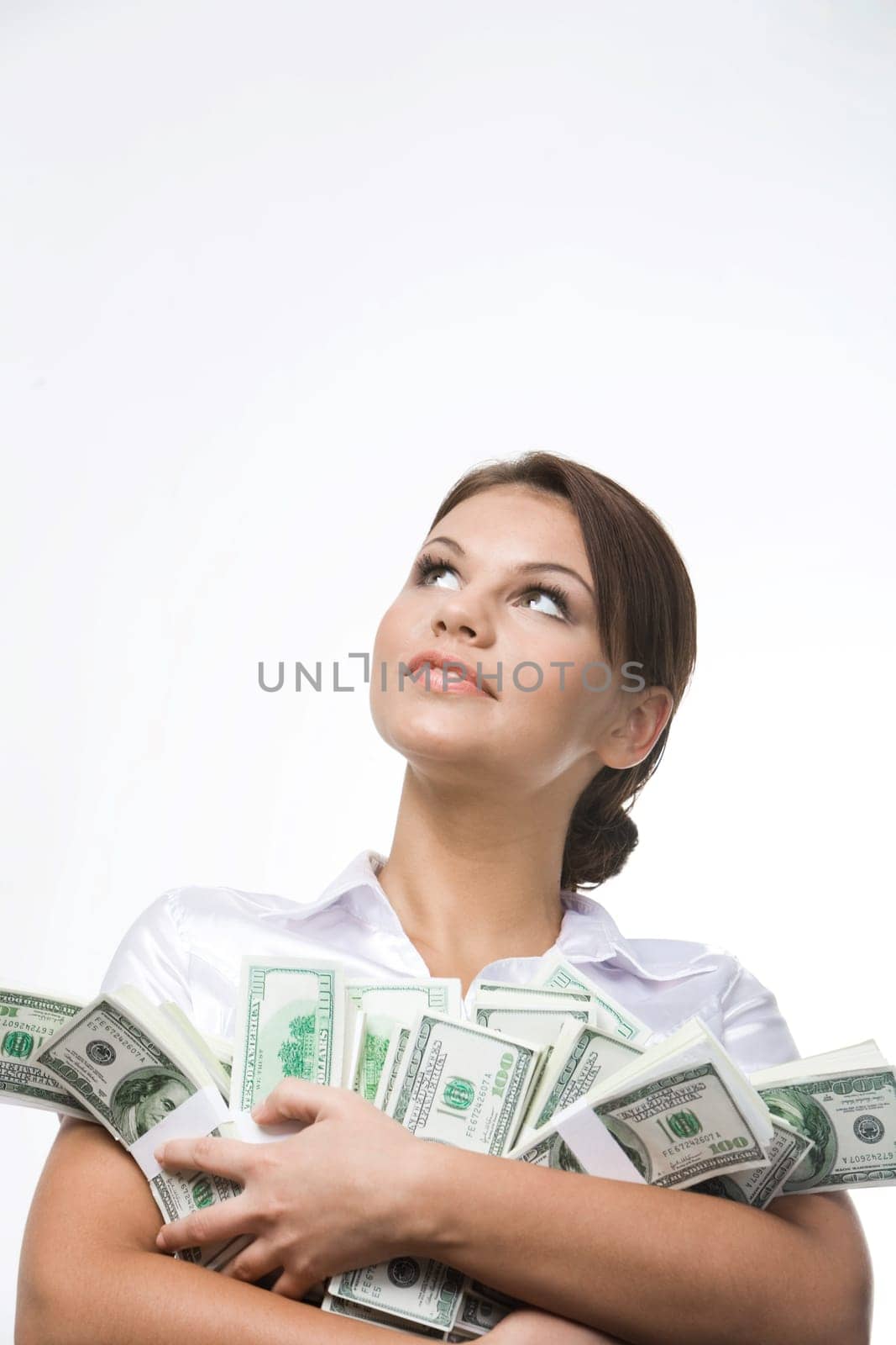 Portrait of charming lady holding bills of dollars and looking upwards
