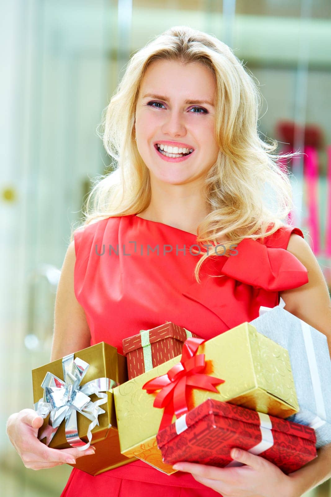 Portrait of pretty woman with giftboxes after good shopping