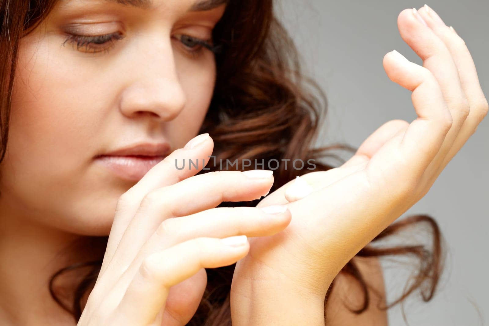 Image of female applying cream on her hands