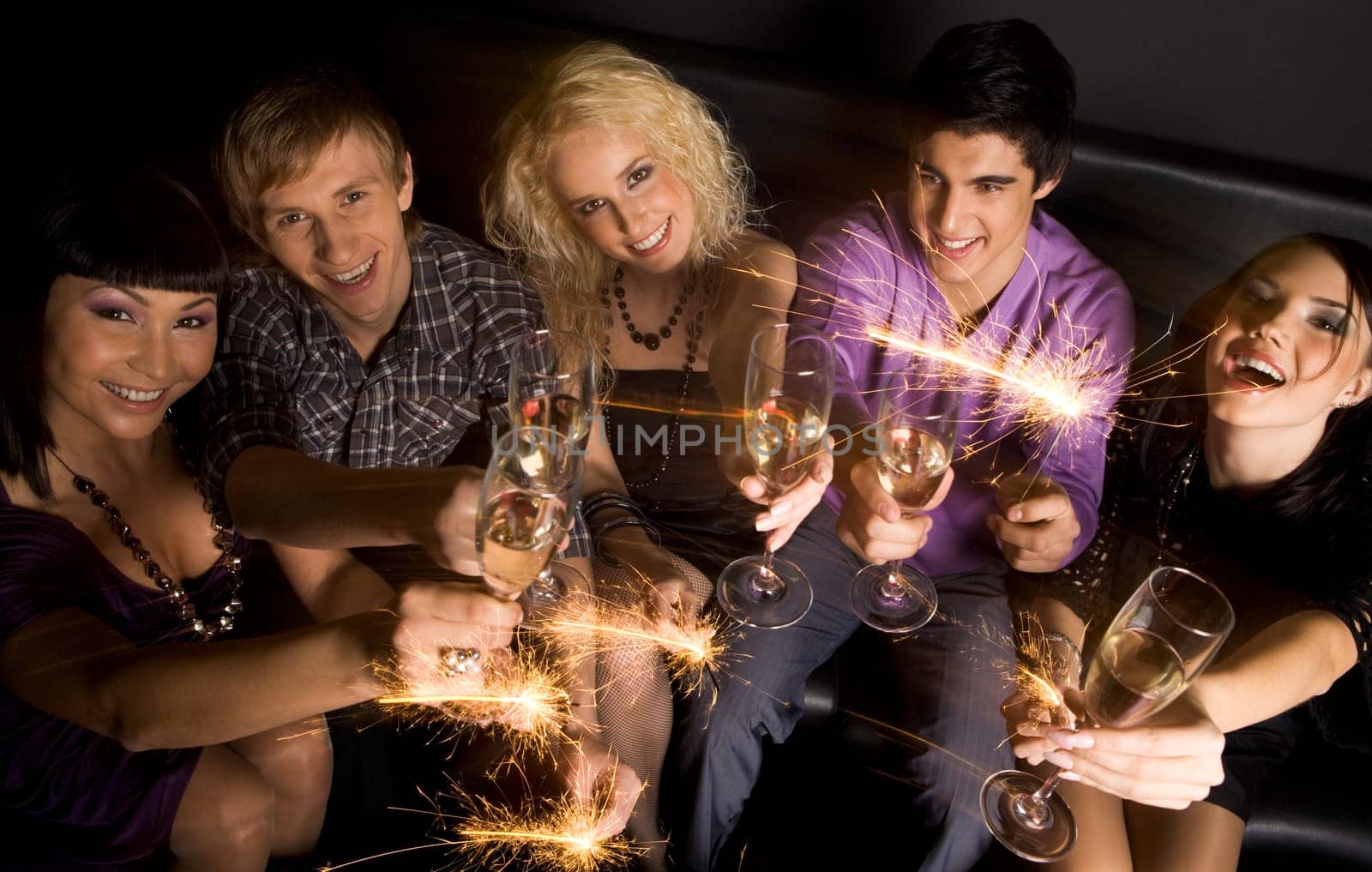 View from above of joyful friends with champagne and sparkling lights in hands during celebration