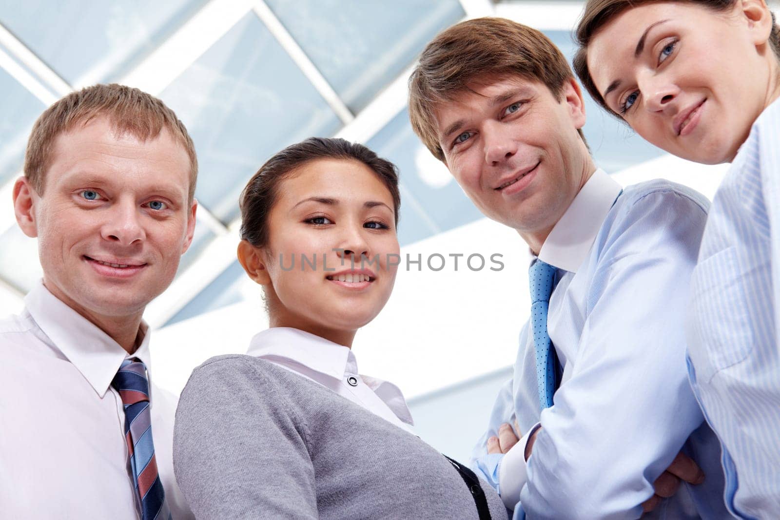 Four businesspeople looking at camera and smiling