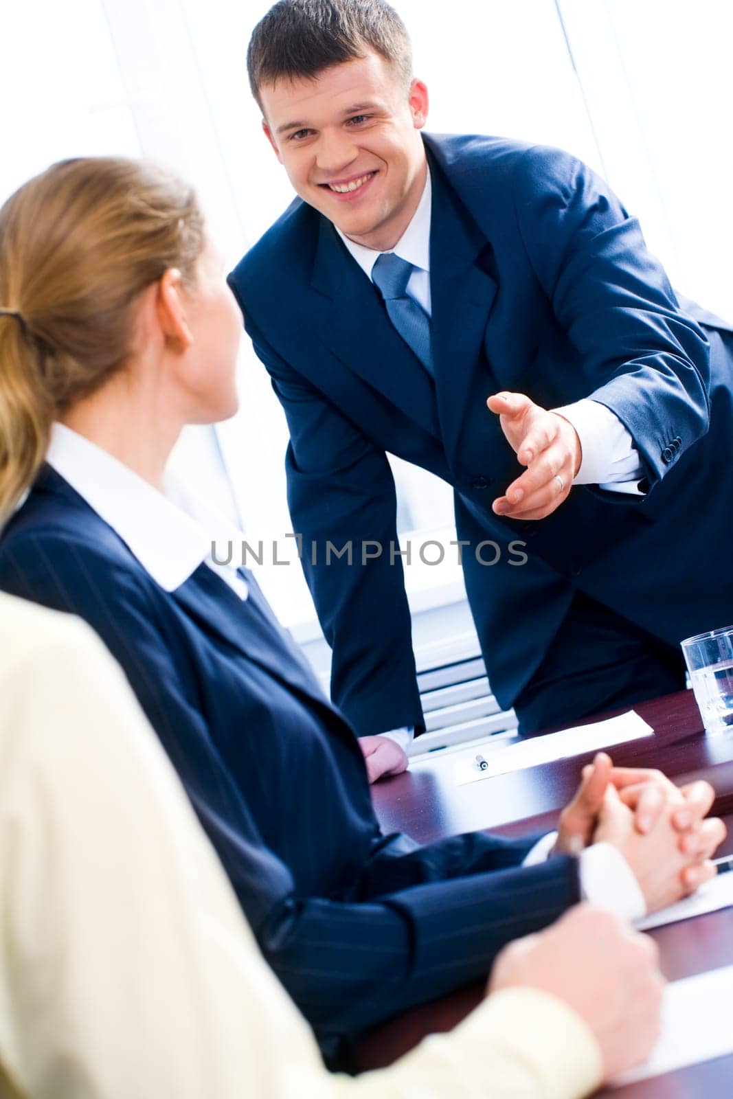 Image of successful businessman giving his hand to partners