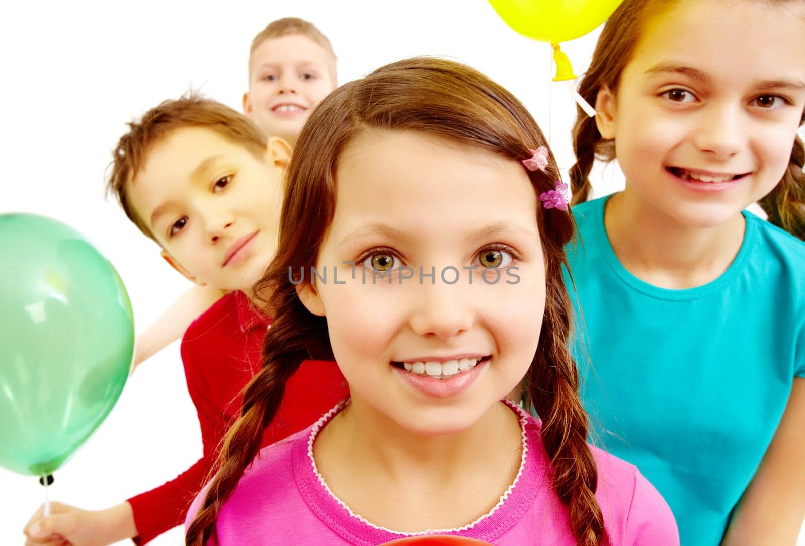 Portrait of smiling kids holding colorful balloons with girl in front