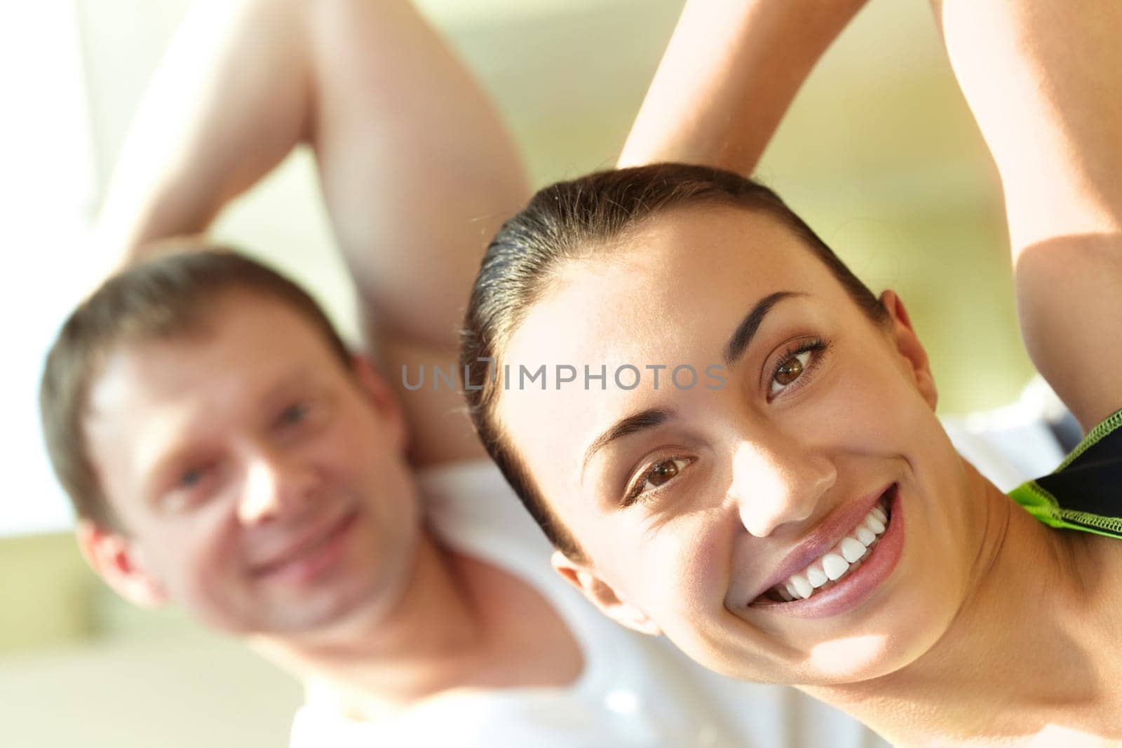 Portrait of young sporty couple doing exercise in gym