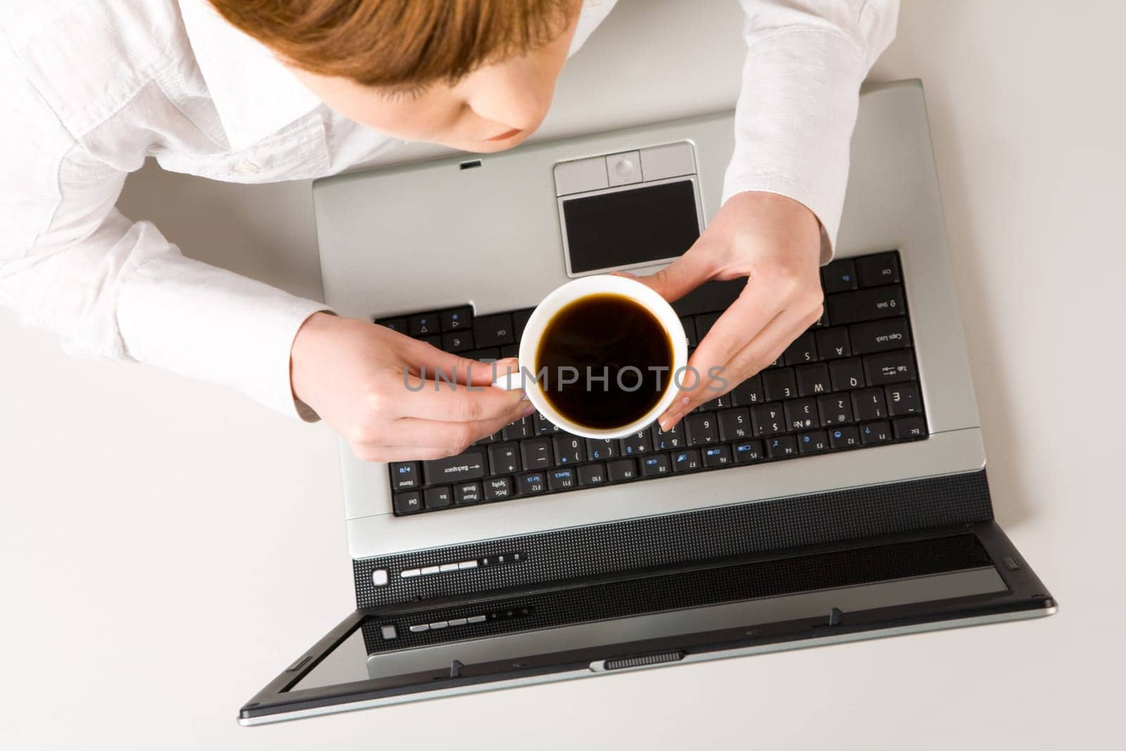 Photo of woman holding cup of coffee at workplace