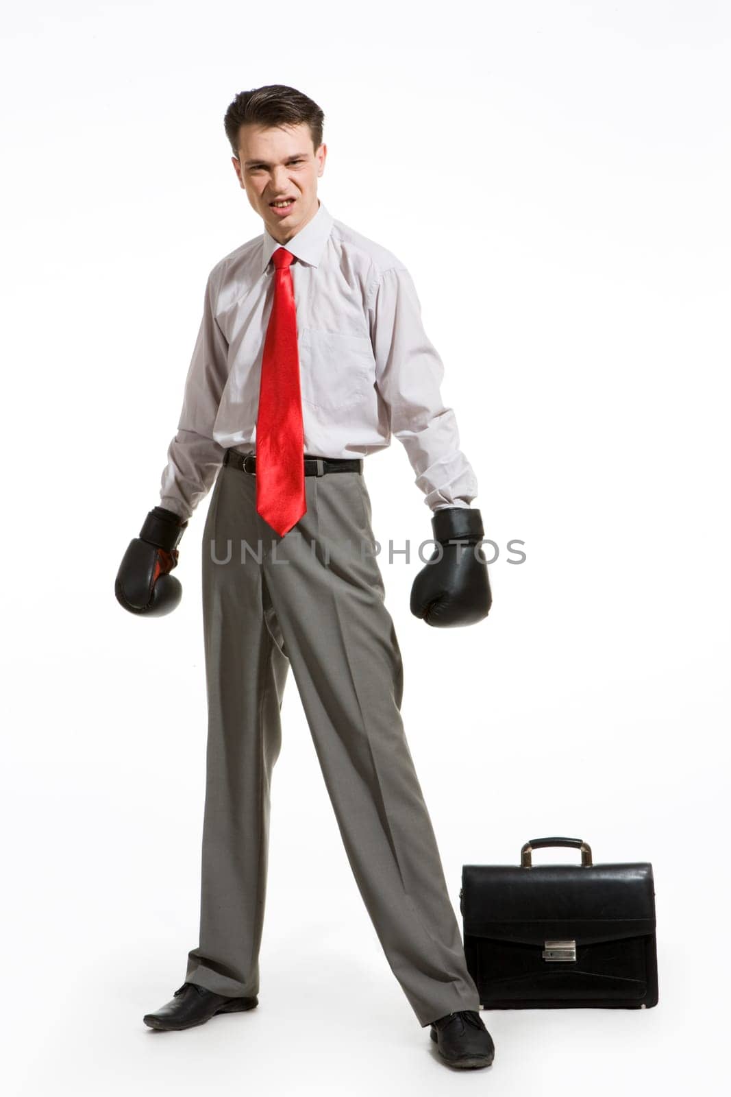 Portrait of aggressive businessman wearing boxing gloves over white background