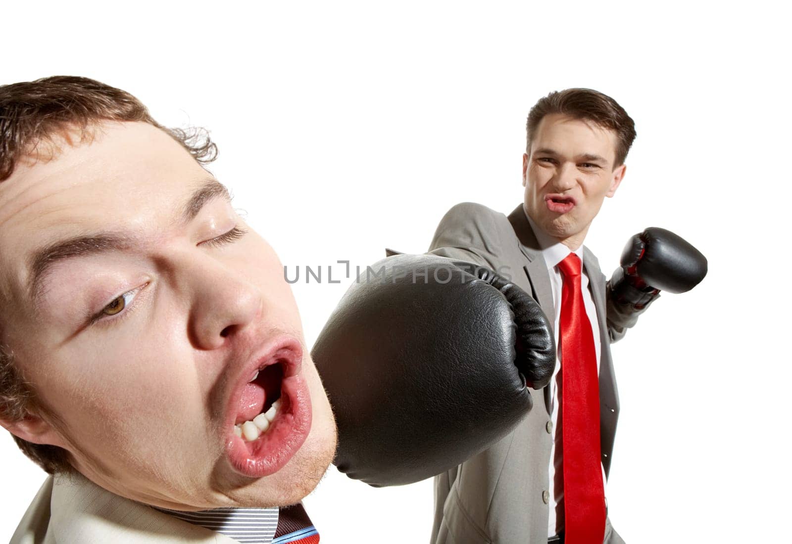 Portrait of aggressive businessman in boxing gloves kicking his rival