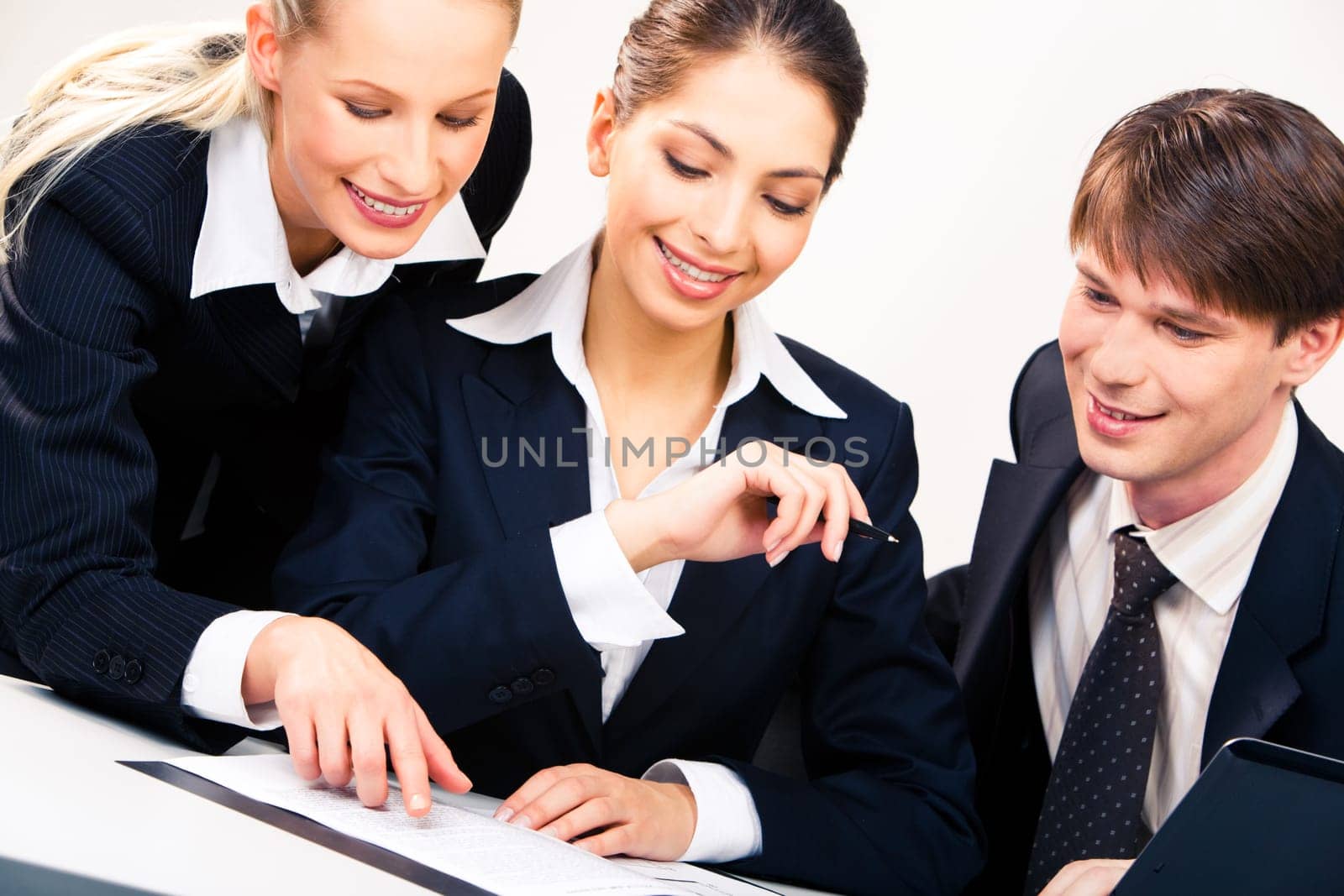 Portrait of three businesspeople looking at document placed on the table