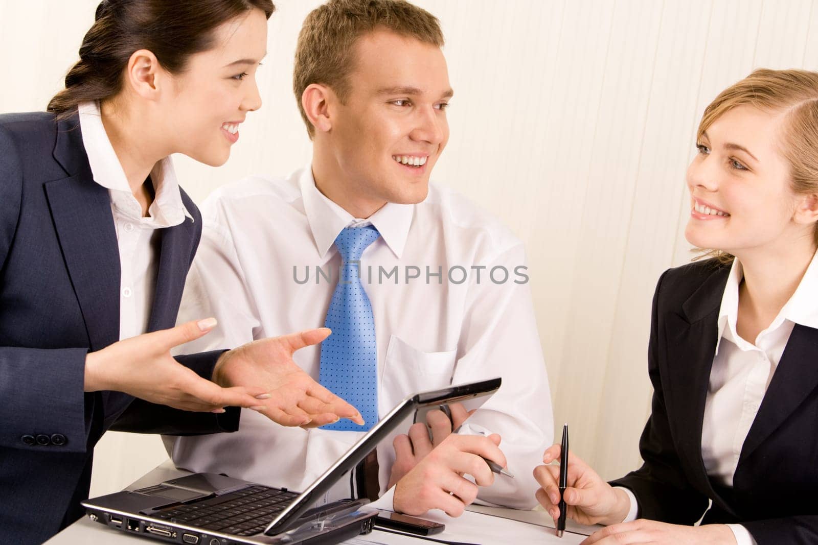Image of confident woman explaining ideas about new project with man near by while looking at smiling employee
