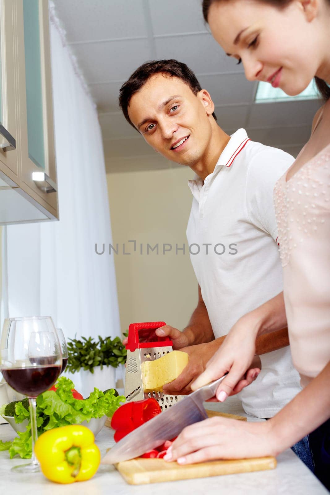 Portrait of amorous couple cooking salad in the kitchen