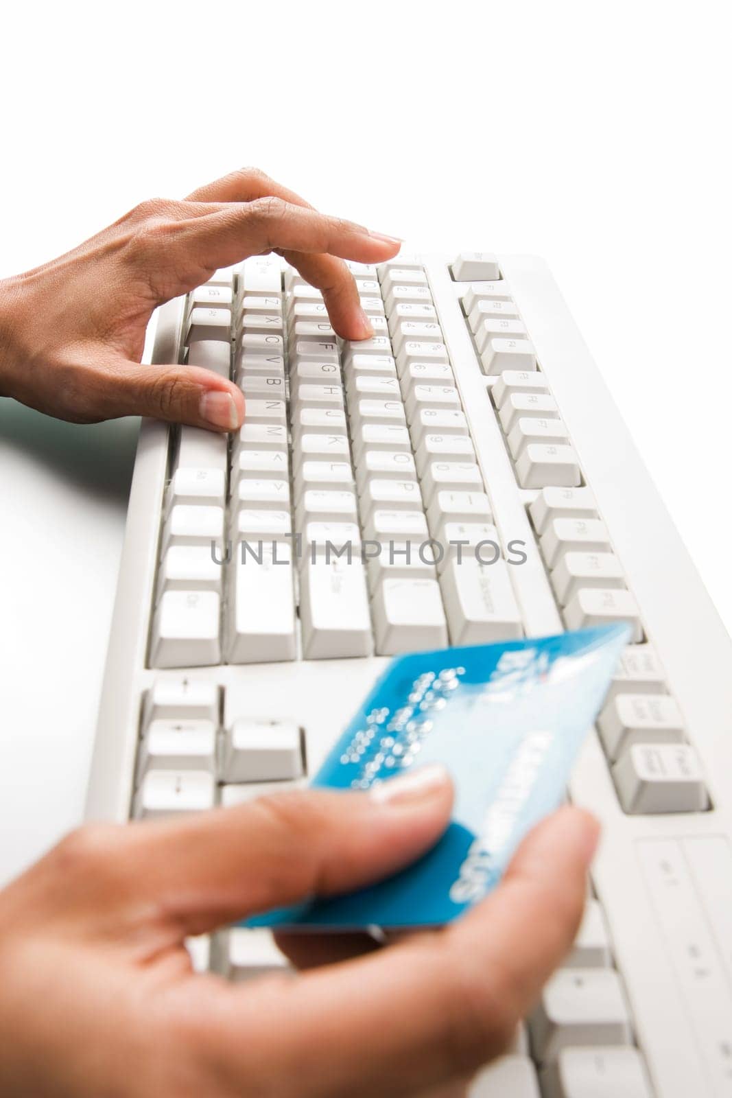 Close-up of female hand over keyboard pressing its button and holding plastic card
