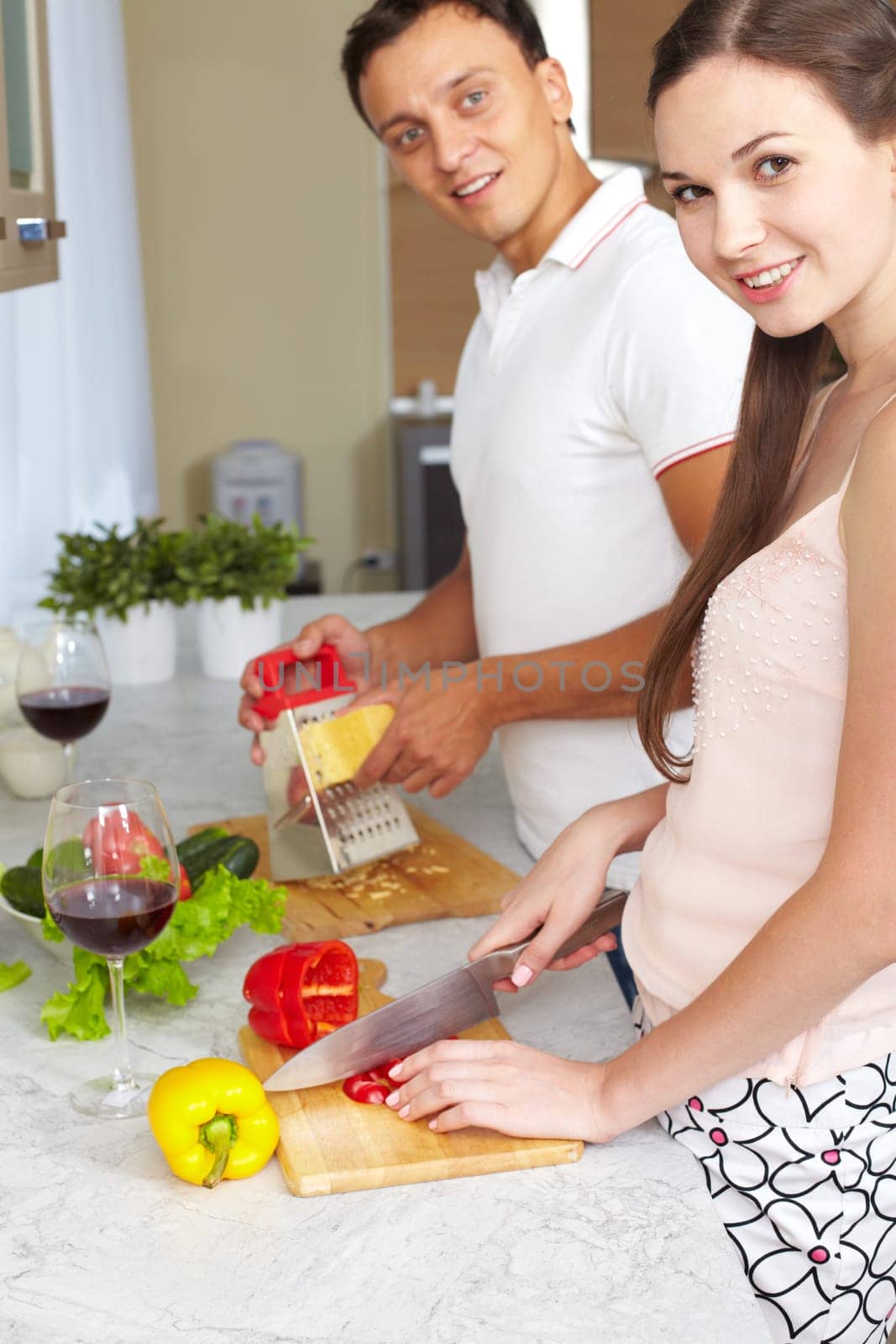 Portrait of amorous couple cooking salad in the kitchen
