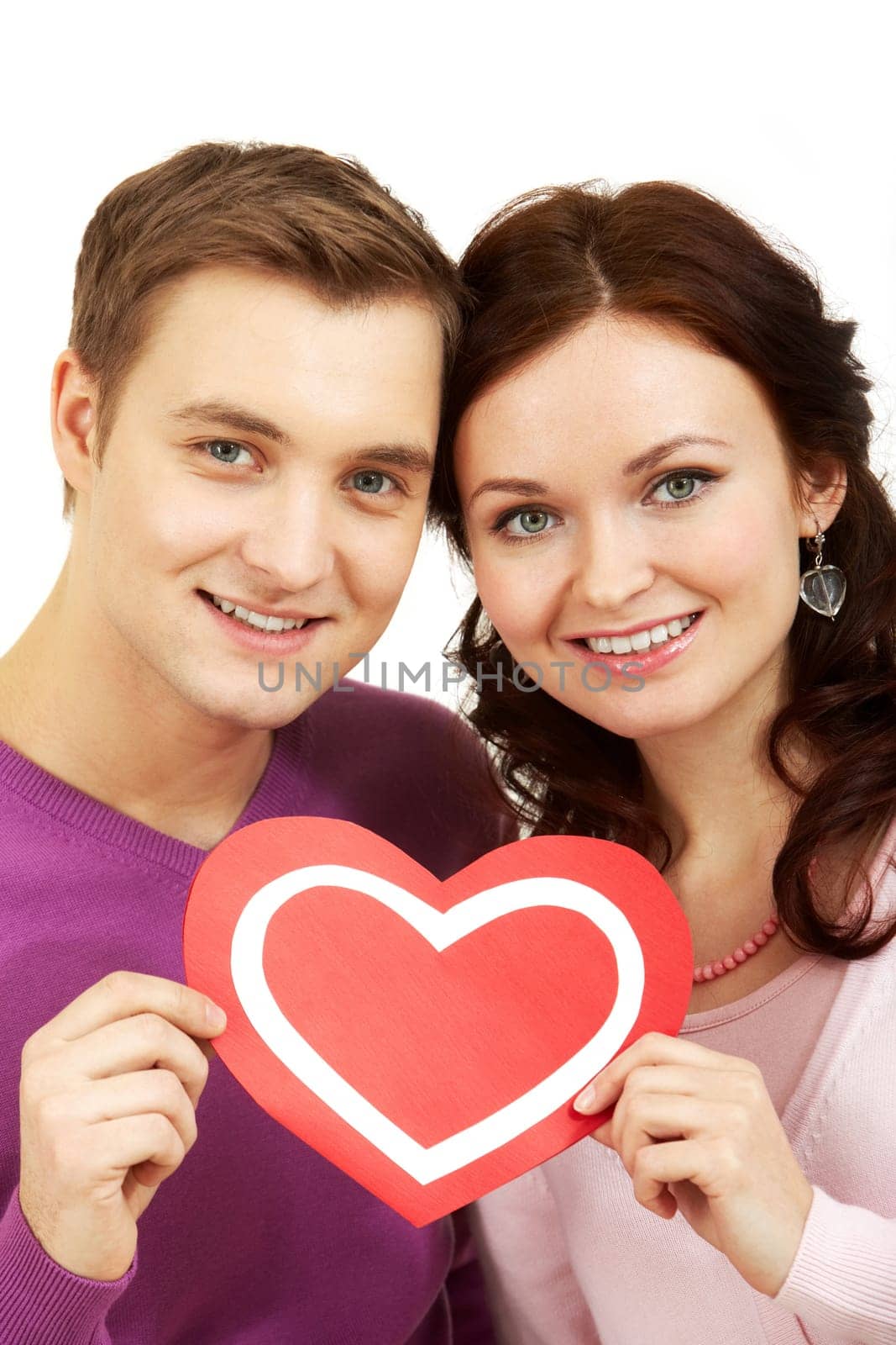 Portrait of a young beautiful couple holding paper heart and smiling