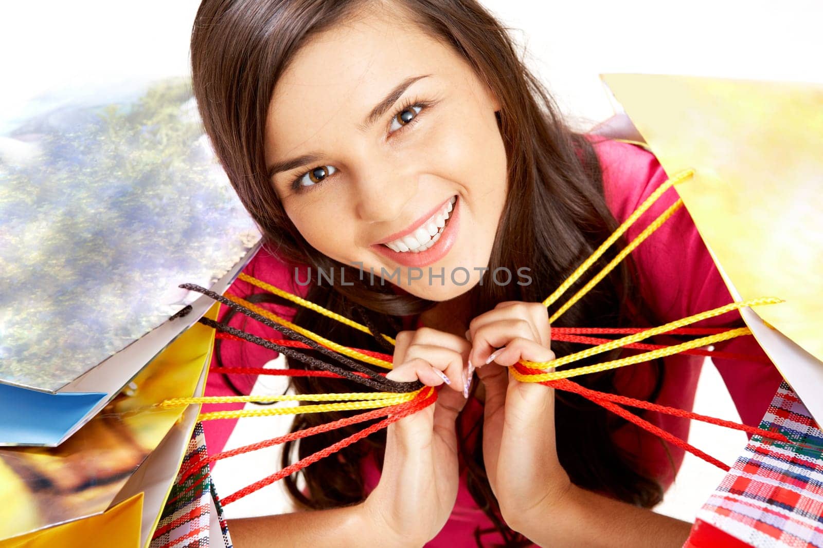 Portrait of happy girl with colorful paper bags looking at camera with smile