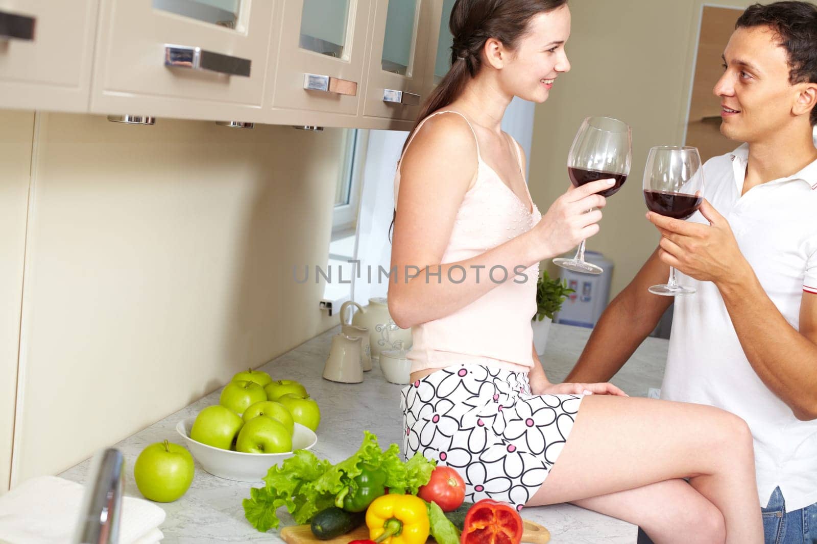 Portrait of amorous couple with wine in the kitchen