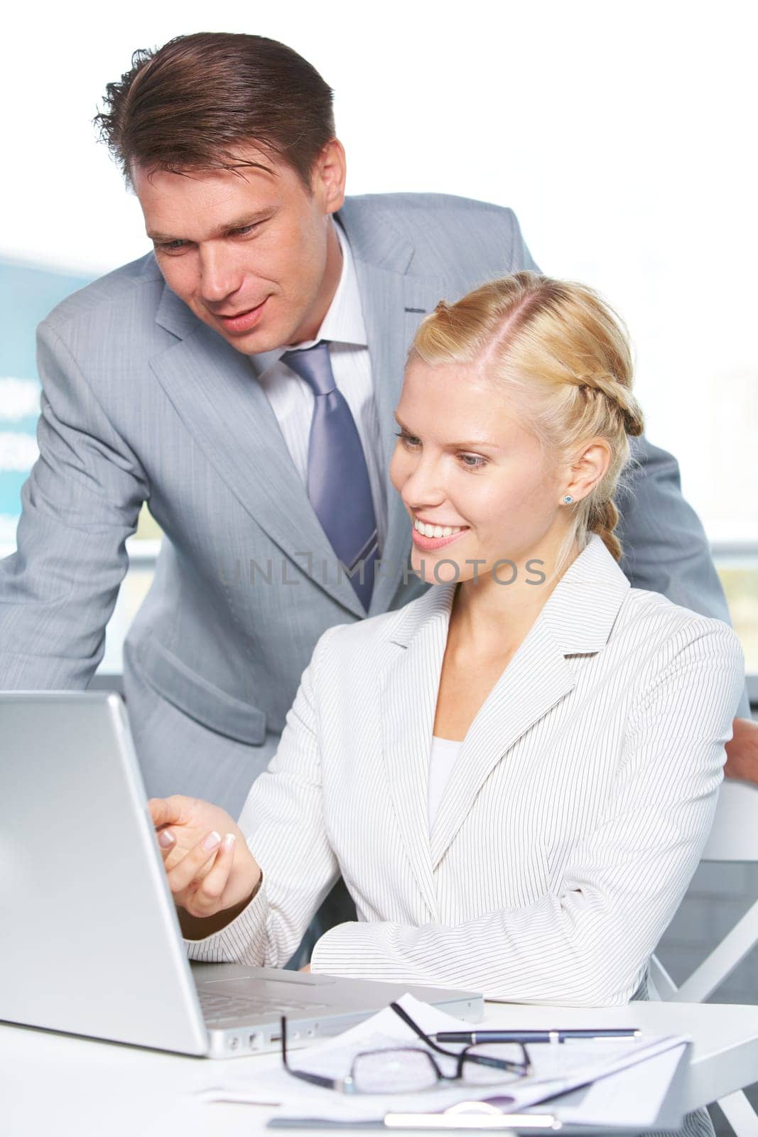 Successful businesswoman explaining something to colleague while they looking at monitor