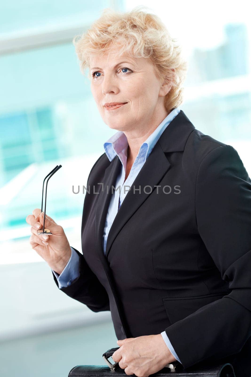 Portrait of smiling middle aged businesswoman with briefcase