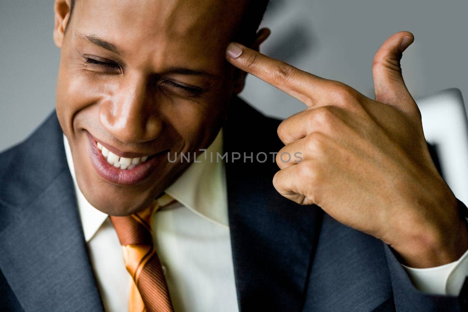 Image of confused man touching his temple with forefinger and smiling