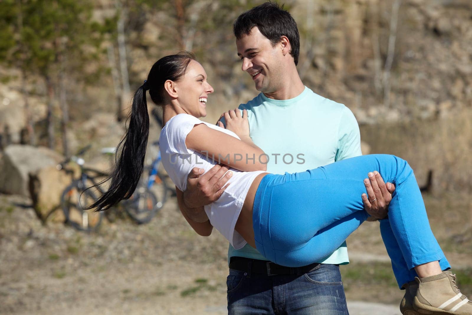 A young man carrying his girl in hands