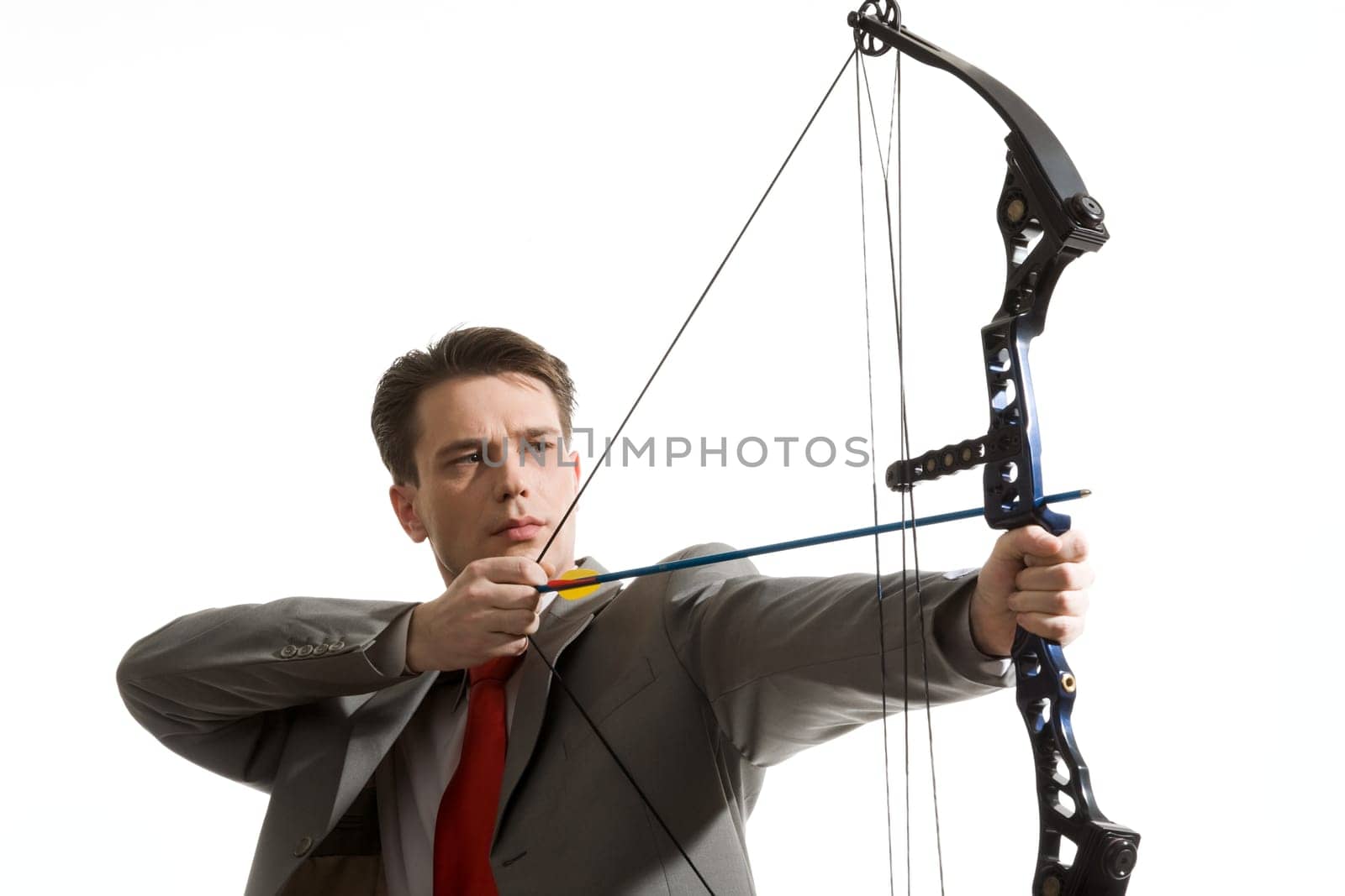 Portrait of concentrated male with crossbow in hands over white background