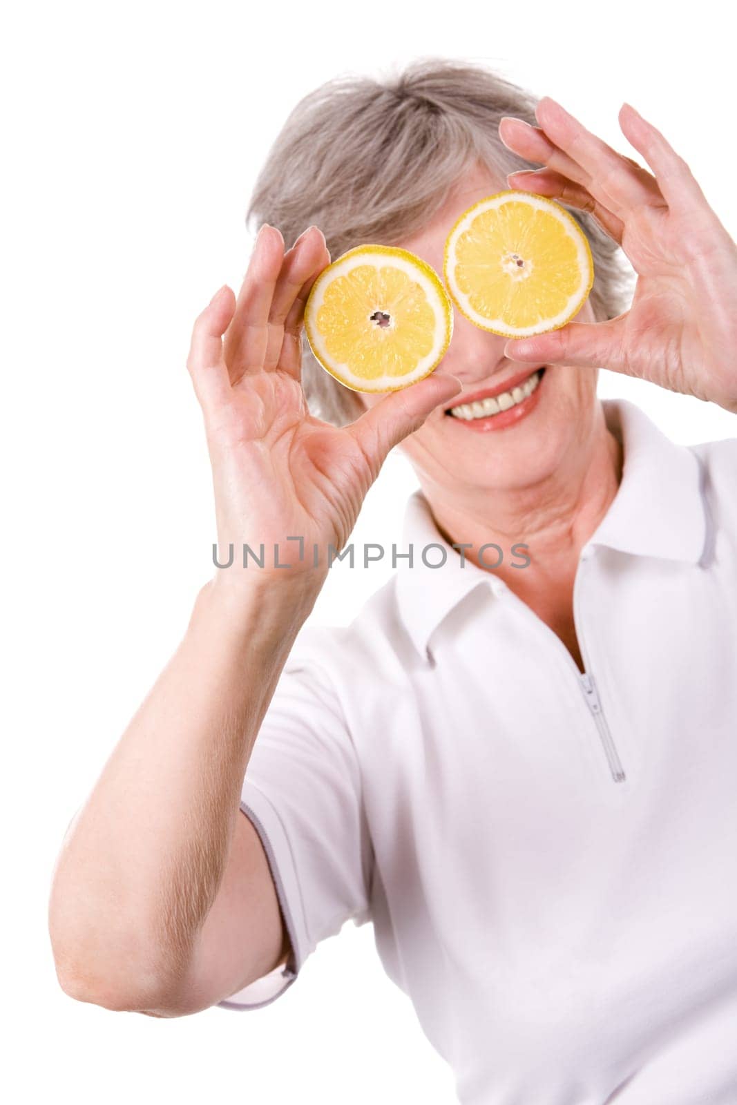 Portrait of mature woman smiling with lemon slices in front of her