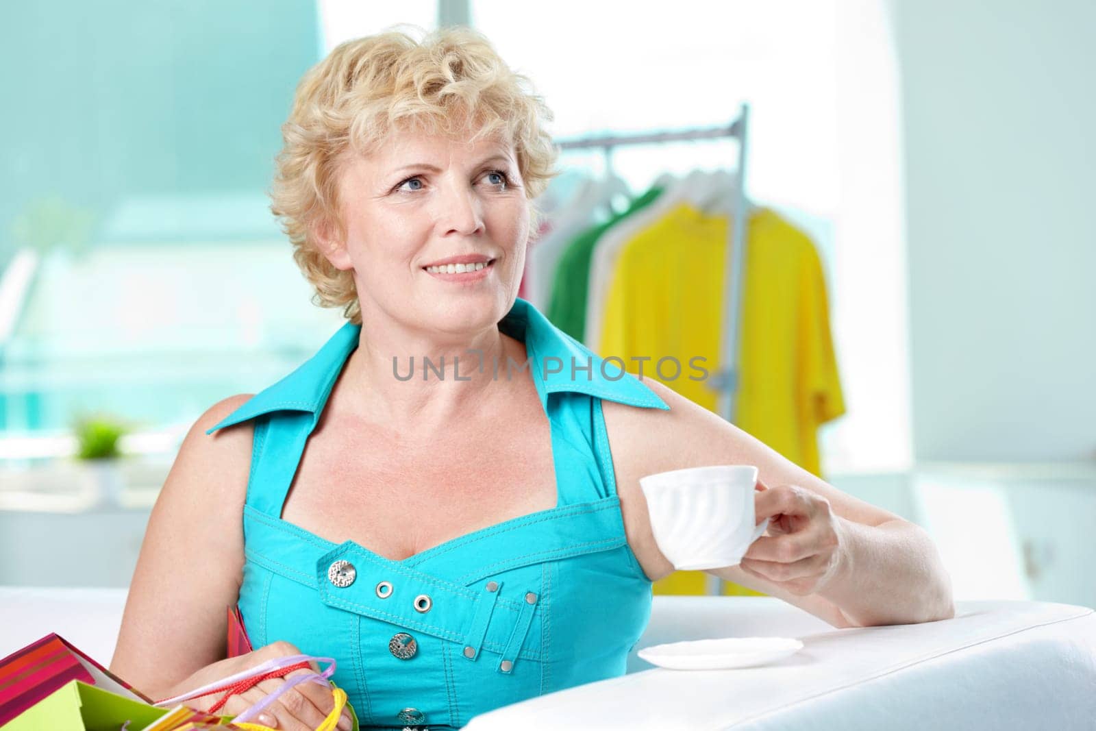 Portrait of middle aged woman with cup of coffee looking somewhere