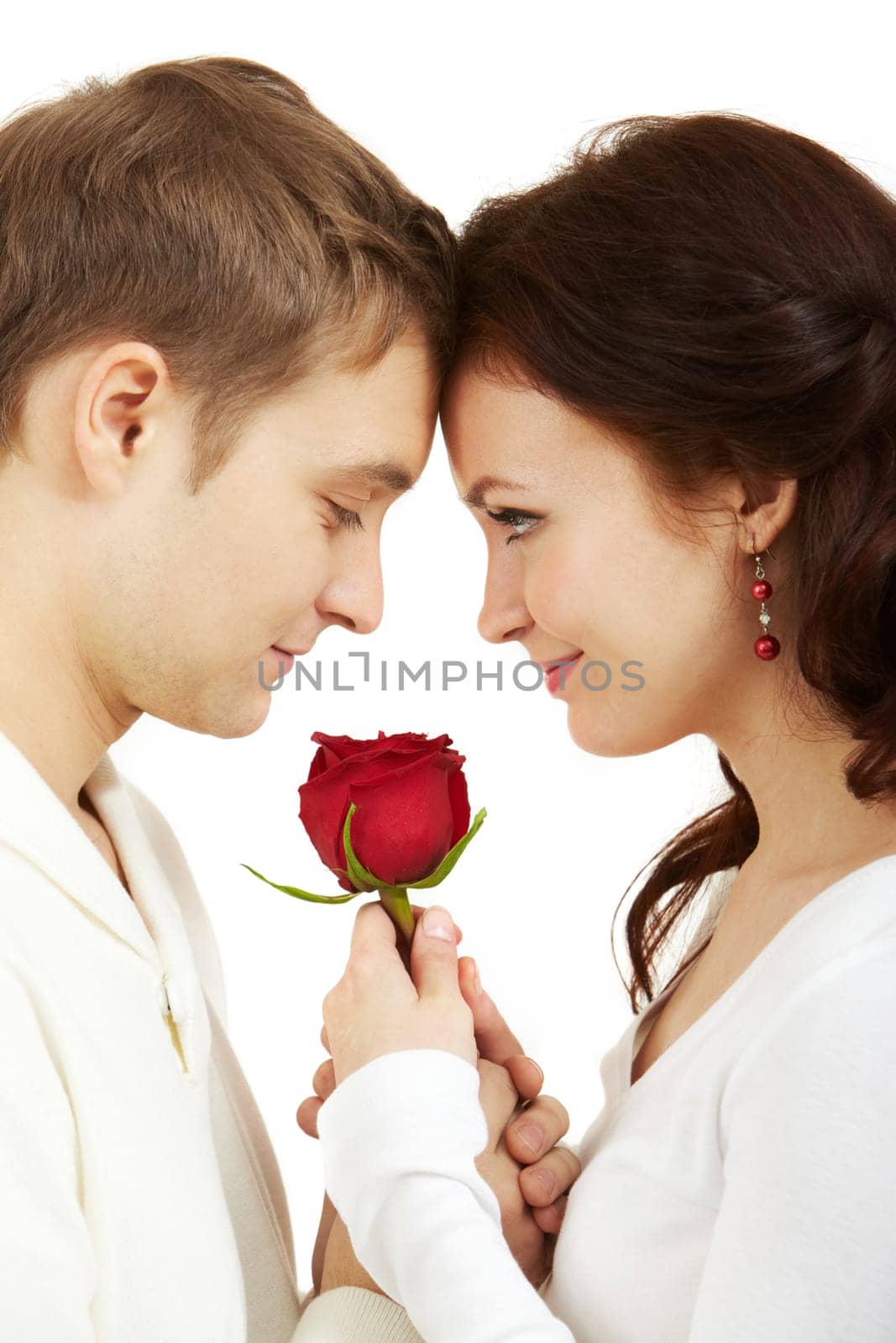 Portrait of two young people looking at each other and holding a rose