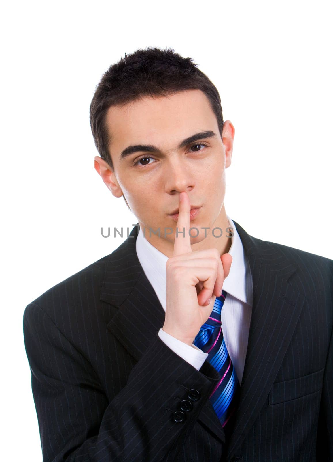 Portrait of businessman showing silence gesture with his forefinger by mouth