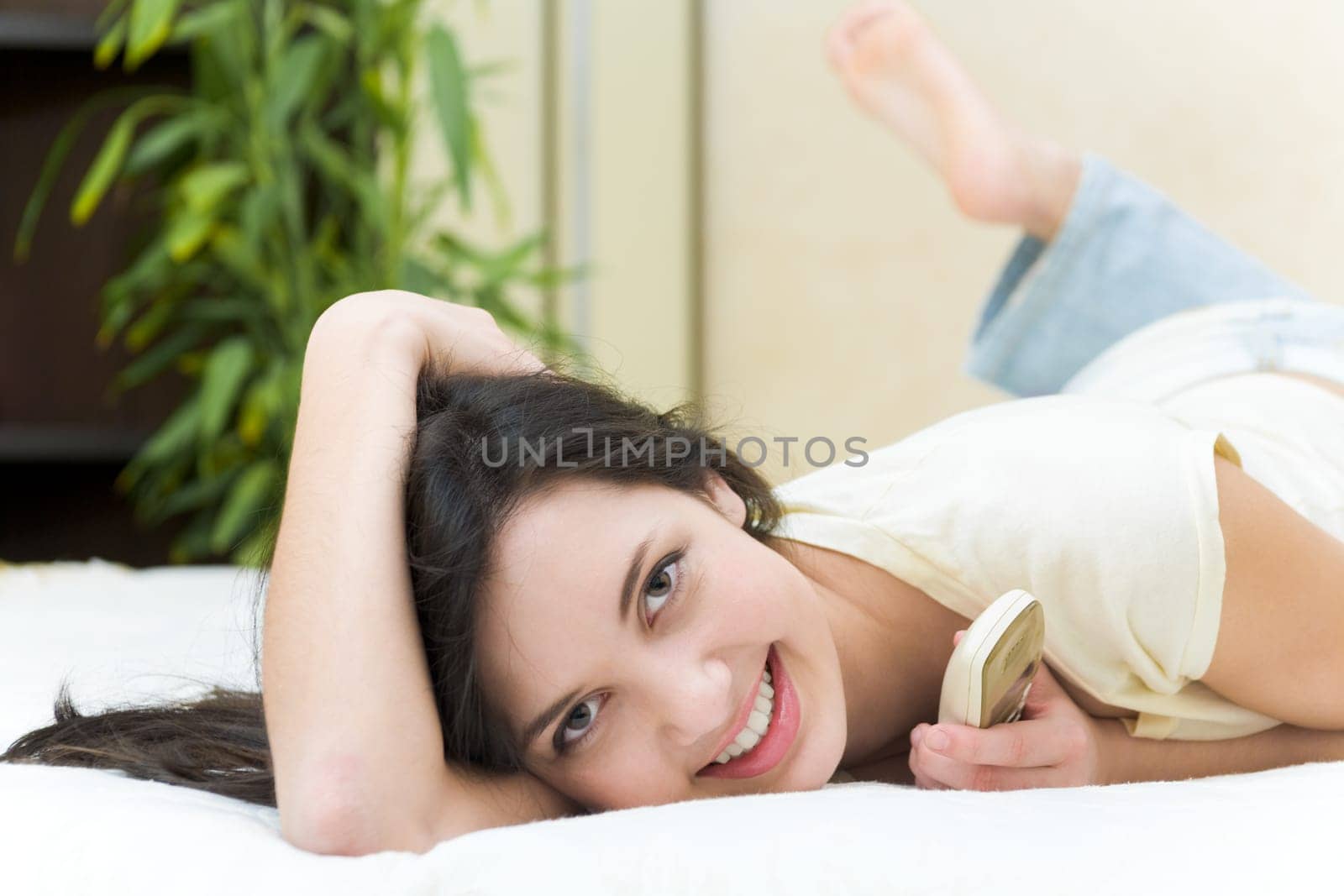 Image of cheerful teenager smiling at camera while having rest at home