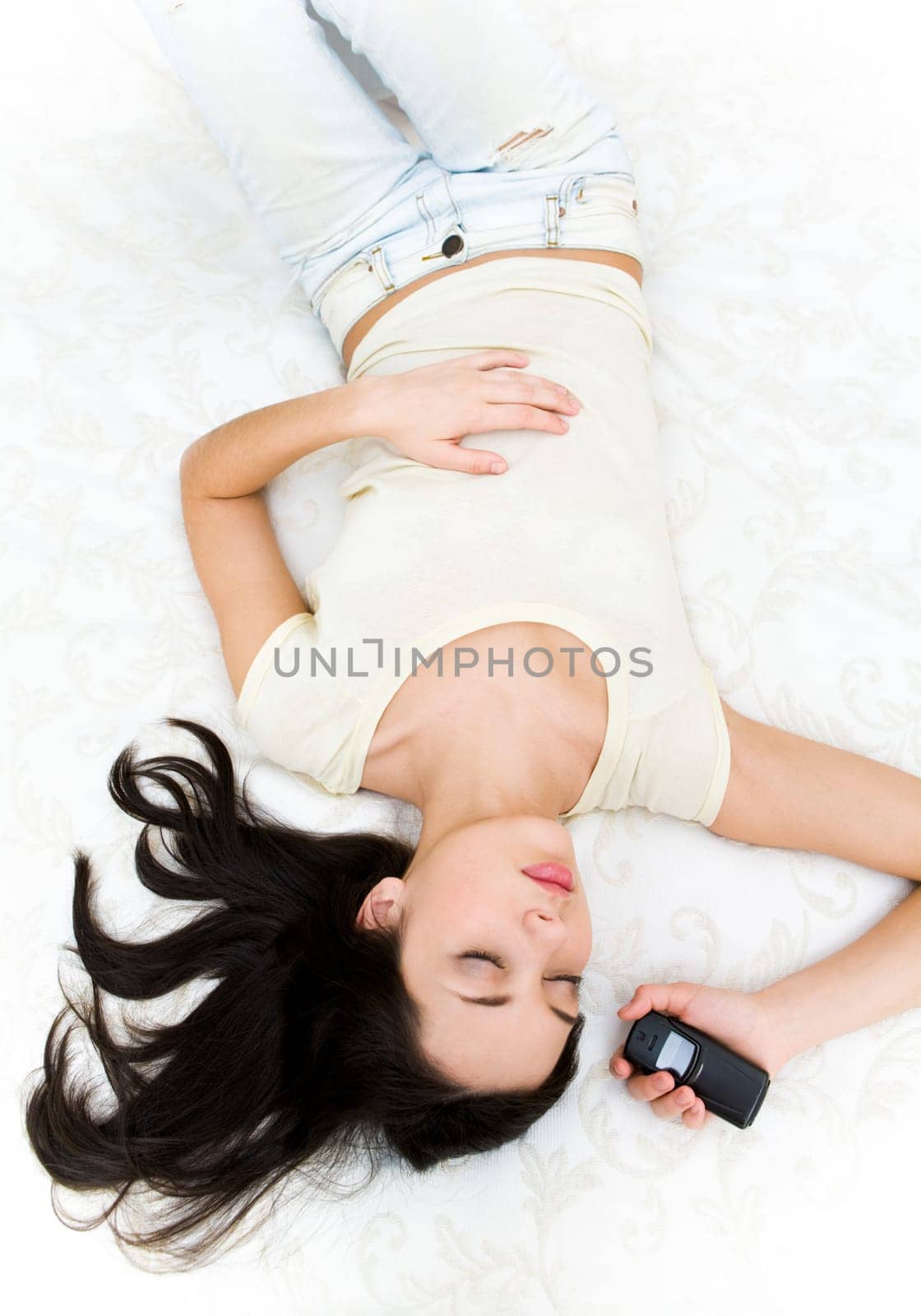 Above shot of sleeping teenager with telephone in hand