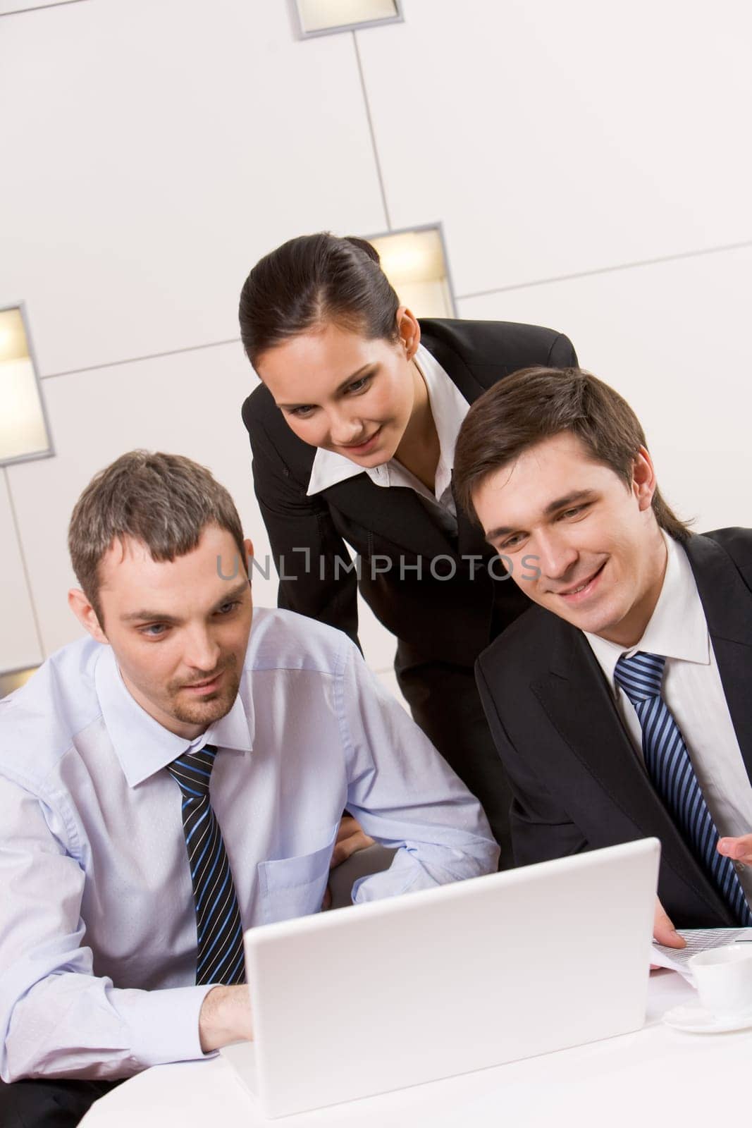 Portrait of executive employees looking at laptop monitor with smiles and thinking about new project